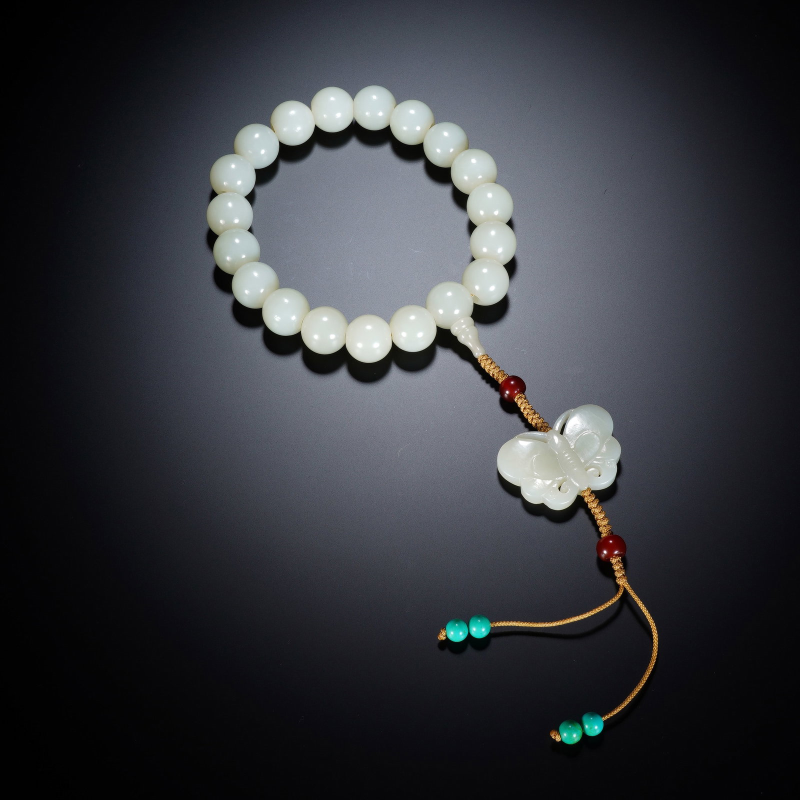 A CHINESE WHITE JADE EIGHTEEN-BEAD PRAYER BRACELET: A CHINESE WHITE JADE EIGHTEEN-BEAD PRAYER BRACELET This scholar's eighteen-bead bracelet features uniform round white nephrite beads of 1.8 cm diameter, with a total weight of 194 grams. Strung on wov