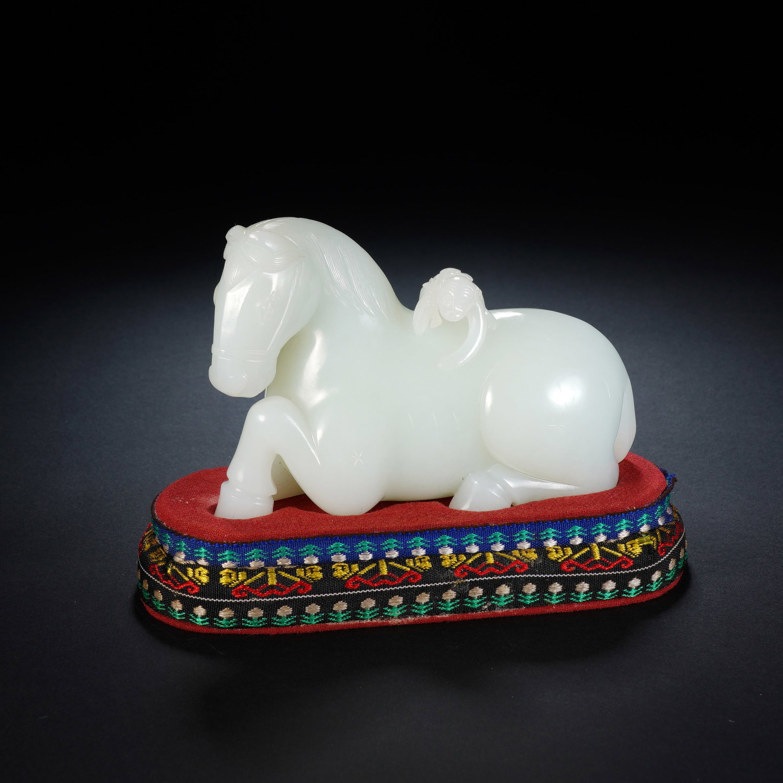 A CHINESE WHITE JADE "HORSE AND MONKEY" ORNAMENT: A CHINESE WHITE JADE "HORSE AND MONKEY" ORNAMENT This polished nephrite jade ornament measures 12cm ? 5cm ? 8cm, standing 10.5cm in full height with its embroidered fabric base, and weighs 502 grams. 