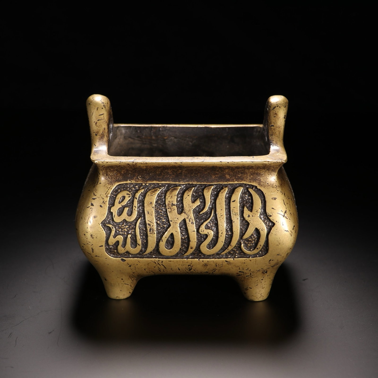A CHINESE BRONZE CENSER WITH ARABIC INSCRIPTIONS: A CHINESE BRONZE CENSER WITH ARABIC INSCRIPTIONS This rectangular bronze censer measures 10cm in height and width, with a total weight of 1085 grams, featuring a warm golden aged patina. It is fitted 
