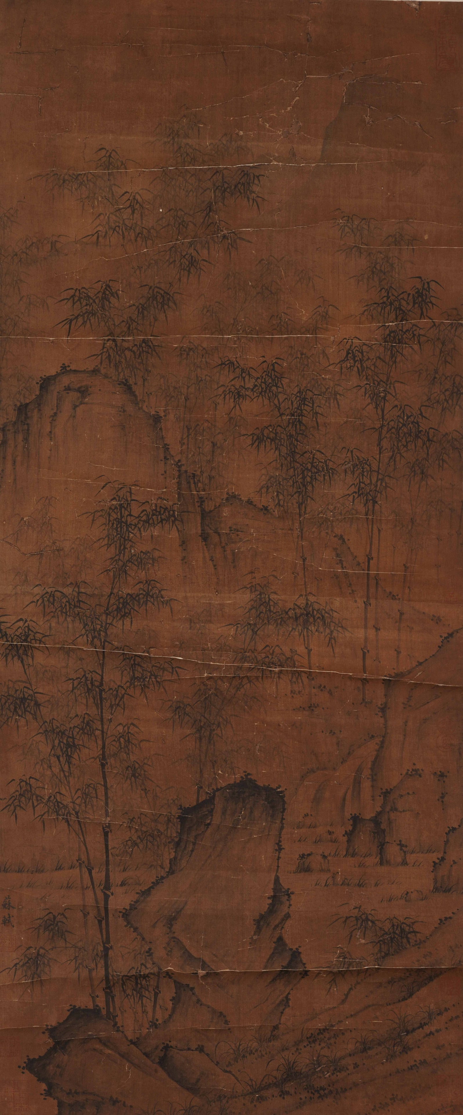 A CHINESE PAINTING OF BAMBOO AND ROCKS, SIGNED SU SHI: A CHINESE PAINTING OF BAMBOO AND ROCKS, SIGNED SU SHI Vertical ink painting on aged amber-toned silk, attributed to Su Shi. The composition features slender upright bamboo stalks with delicate leaves 