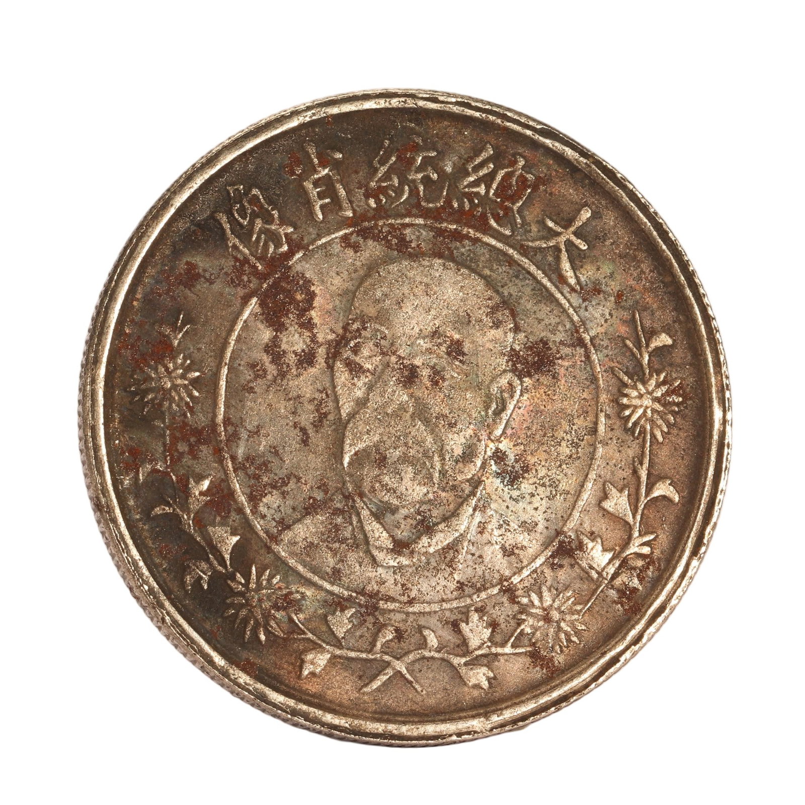 A CHINESE PRESIDENTIAL PORTRAIT SILVER DOLLAR: A CHINESE PRESIDENTIAL PORTRAIT SILVER DOLLAR This round silver coin features a central bust portrait encased within a thin circular border. Curved Chinese characters reading ?Portrait of the Grand Pr