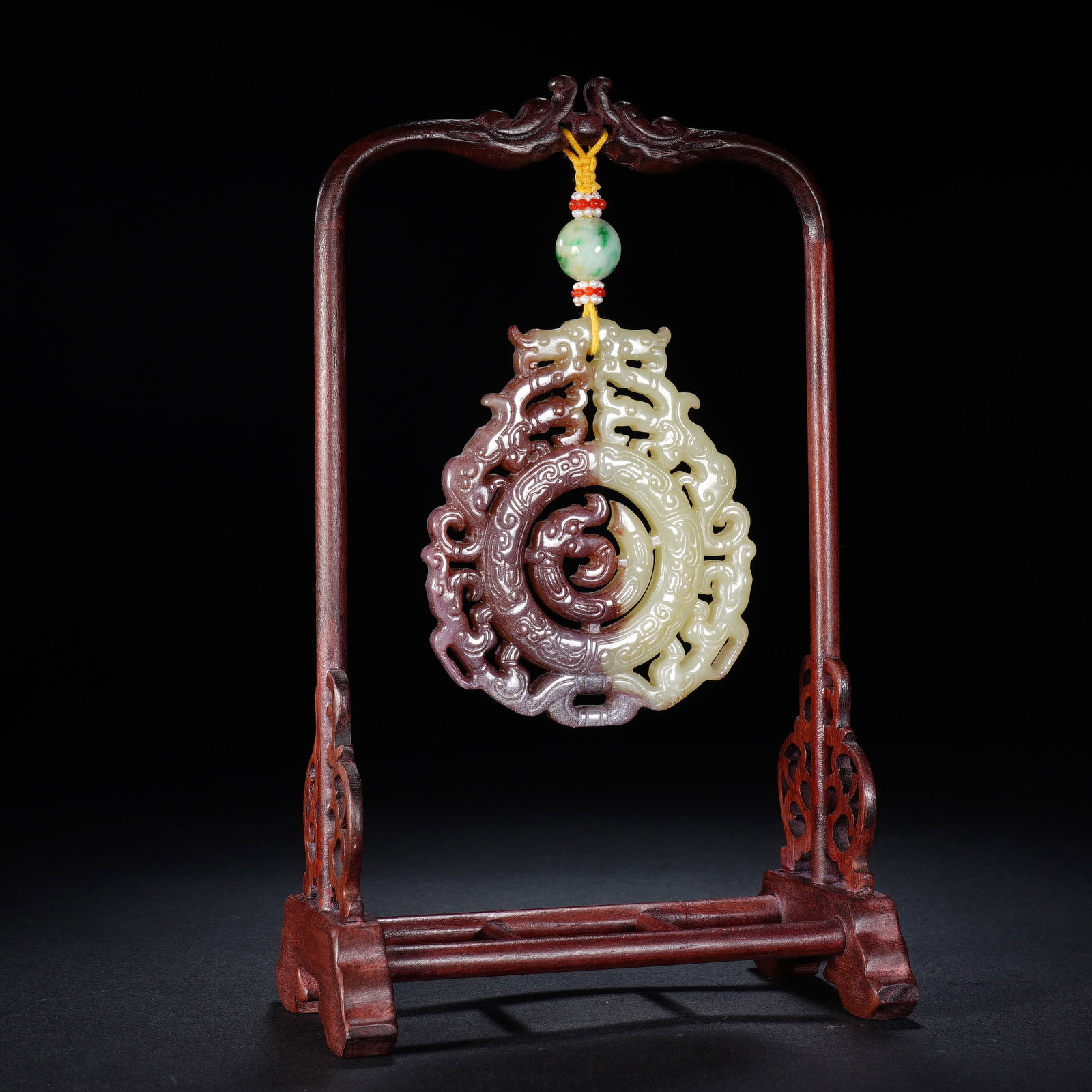 A CHINESE PIERCED CARVED JADE PENDANT: A CHINESE PIERCED CARVED JADE PENDANT This singular pierced jade pendant measures 7.5 cm by 9 cm with a thickness of 0.7 cm and weighs 83 grams. It features elaborate openwork interlaced dragon scroll