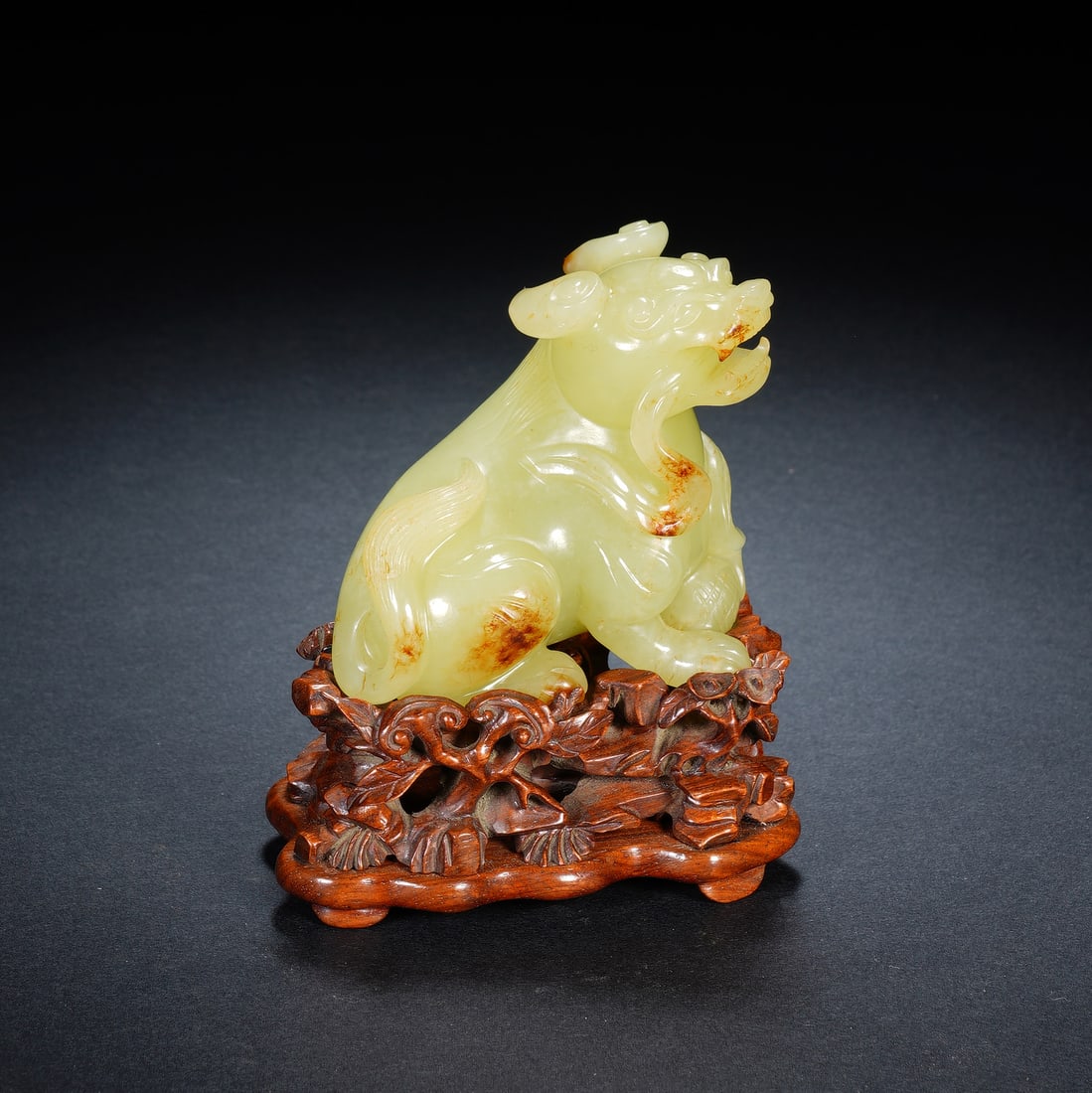 A CHINESE RUSSET YELLOW JADE MYTHICAL BEAST: A CHINESE RUSSET YELLOW JADE MYTHICAL BEAST Carved from smooth pale yellow nephrite jade naturally streaked with warm russet skin inclusions, this auspicious mythical beast sits in a poised alert crou