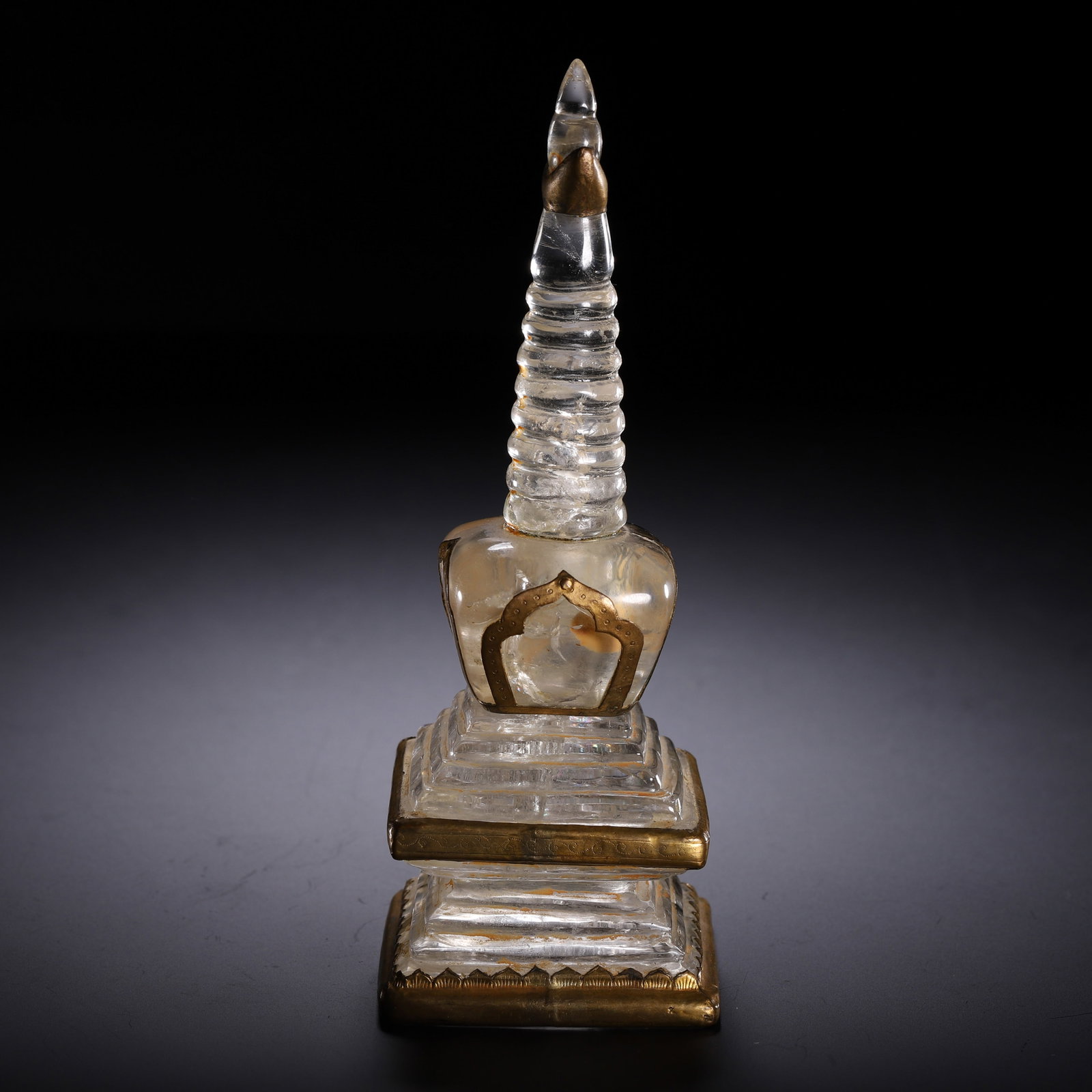 A CHINESE ROCK CRYSTAL GILT MOUNTED STUPA: A CHINESE ROCK CRYSTAL GILT MOUNTED STUPA This miniature Tibetan-style reliquary stupa is fully carved from transparent rock crystal with subtle natural faint internal inclusions, accented with polish