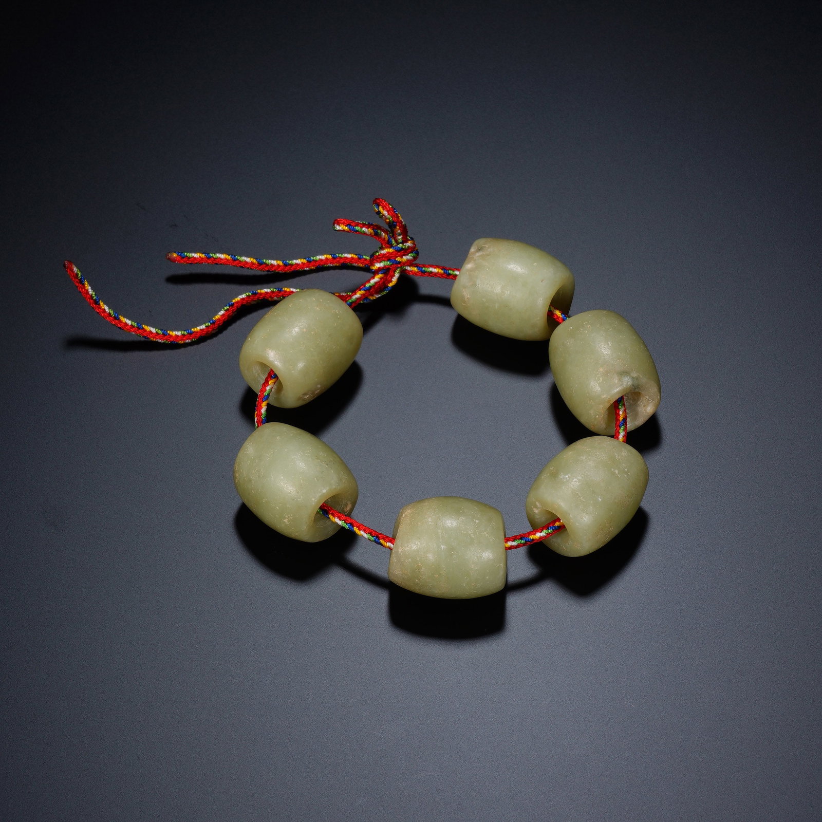 A CHINESE ARCHAIC JADE BARREL BEAD BRACELET: A CHINESE ARCHAIC JADE BARREL BEAD BRACELET This bracelet consists of six matching barrel-shaped jade beads, each measuring 2.6cm ? 2.4cm, with a total weight of 114 grams. Each bead is uniformly holl