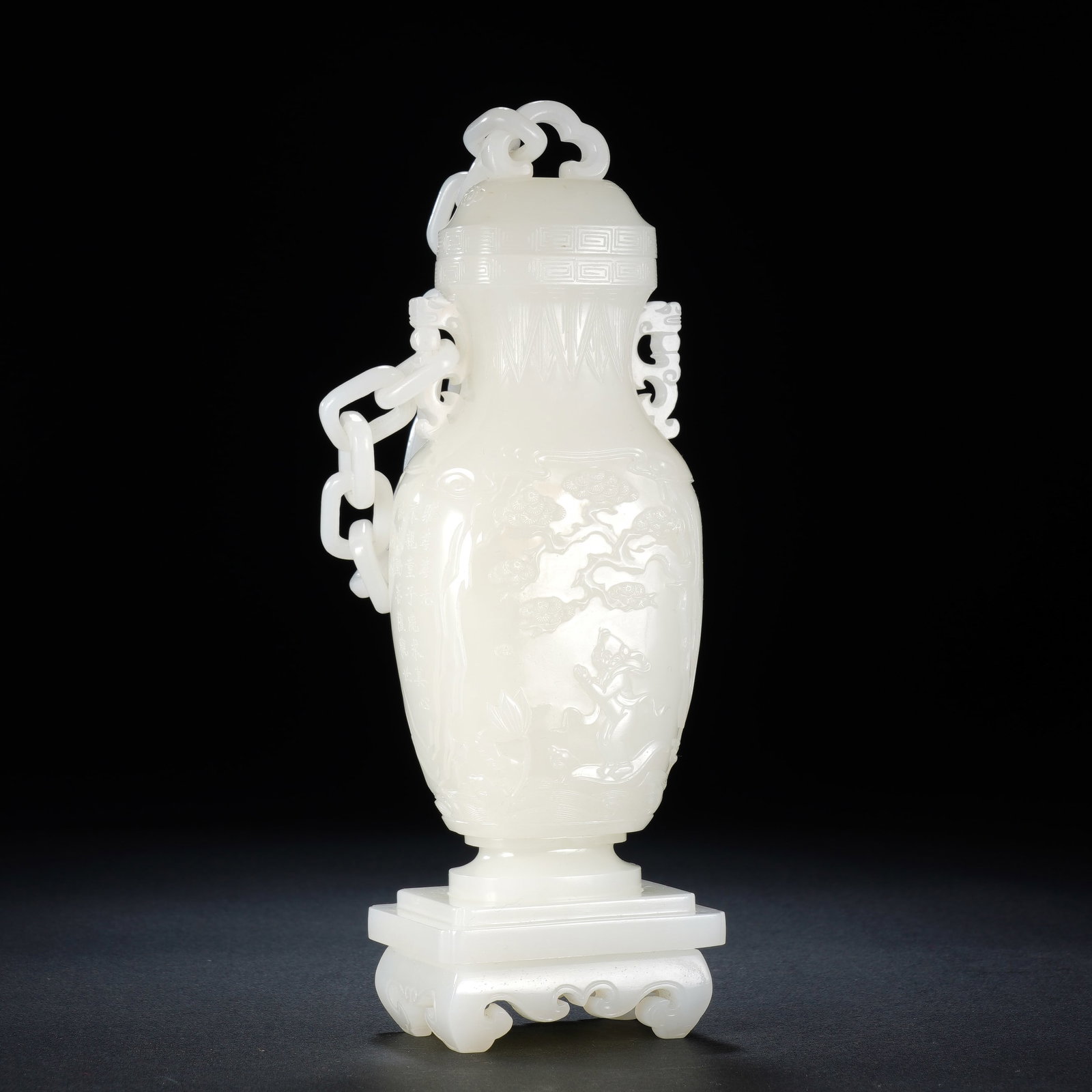 A CHINESE WHITE JADE LANDSCAPE FIGURAL VASE: A CHINESE WHITE JADE LANDSCAPE FIGURAL VASE This carved white nephrite vase measures 5.5 cm wide, 4 cm deep and 16.5 cm tall, weighing 370 grams. Rendered from pure milky white jade with a sleek gloss