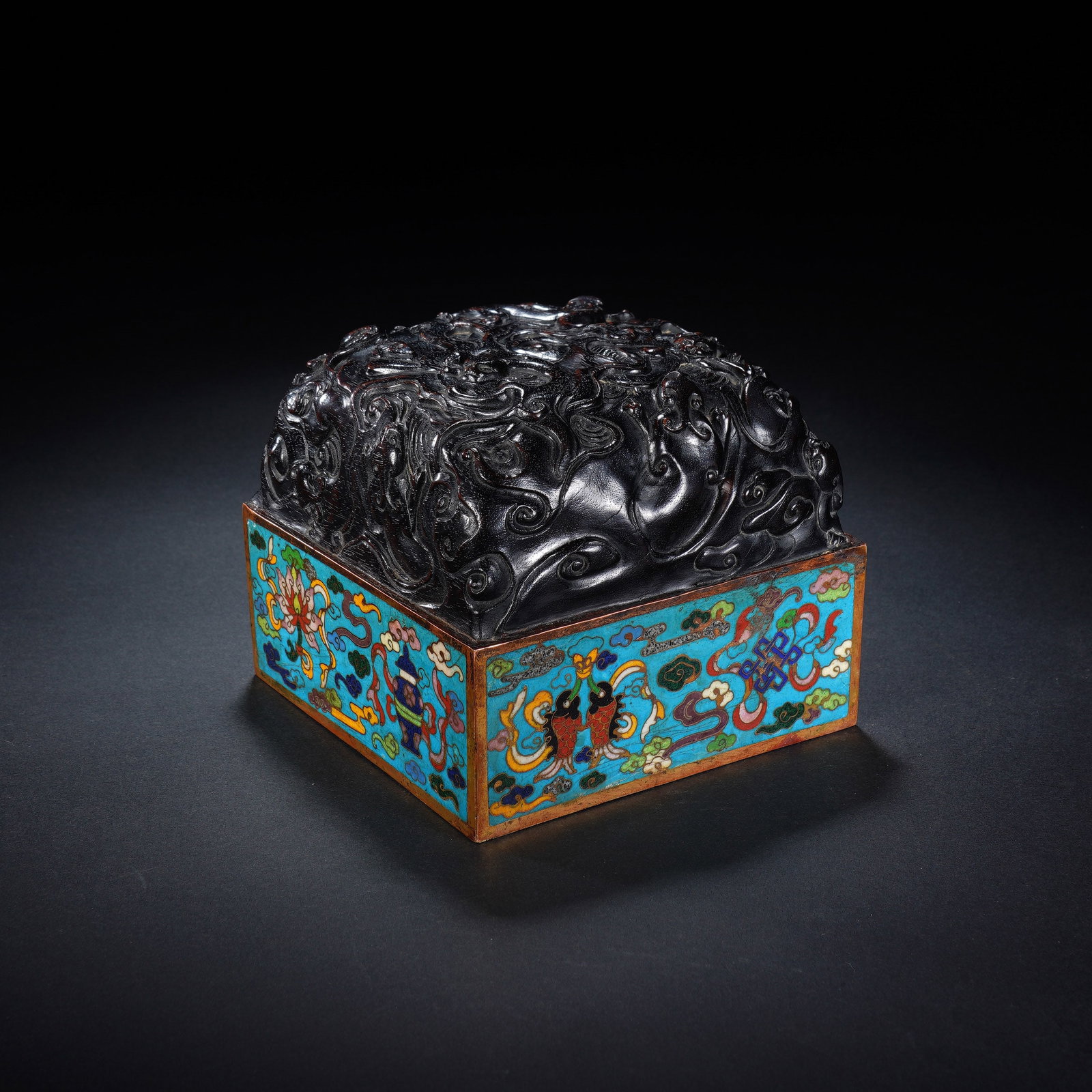 A CHINESE ZITAN CLOISONNE SEAL BOX: A CHINESE ZITAN CLOISONNE SEAL BOX This square seal box measures 11 cm by 11 cm with a height of 9 cm and weighs 1283 grams. Its domed lid is carved from solid zitan hardwood with dense, undulating op