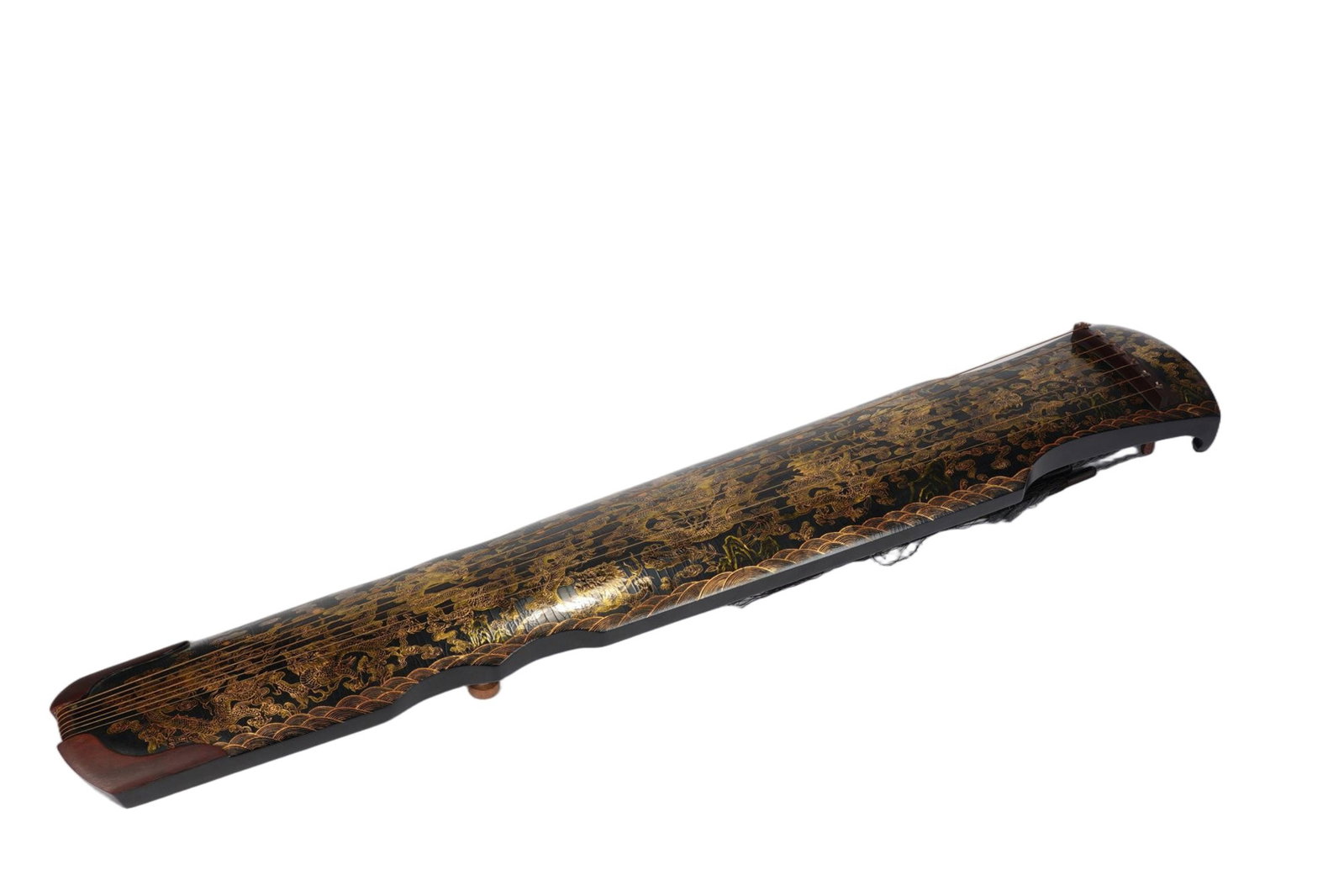 A CHINESE GOLD PAINTED LACQUER GUQIN: A CHINESE GOLD PAINTED LACQUER GUQIN This single traditional seven-stringed guqin measures 20 cm wide, 11 cm deep and 122 cm in full length. The instrument's surface is finished with elaborate gold-sp