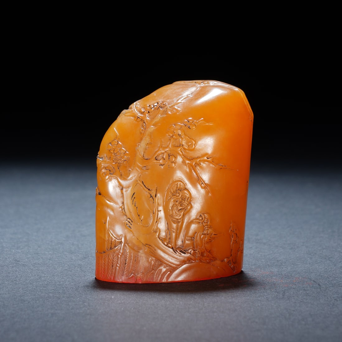 A CHINESE TIANHUANG STONE FIGURAL LANDSCAPE SEAL: A CHINESE TIANHUANG STONE FIGURAL LANDSCAPE SEAL Crafted from fine natural tianhuang stone with a luminous warm amber hue and smooth glossy polish, this free-form seal is decorated with masterful bo y