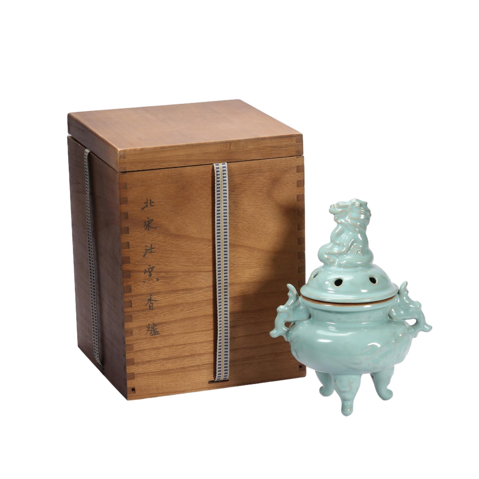 A CHINESE RU-TYPE CELADON DRAGON TRIPOD INCENSE BURNER WITH BOX: A CHINESE RU-TYPE CELADON DRAGON TRIPOD INCENSE BURNER WITH BOX This lidded censer is entirely covered in soft pale sky celadon glaze with a gentle silky sheen. The rounded body is fitted with a pair 