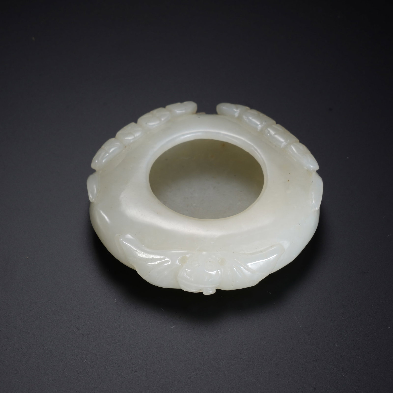 A CHINESE WHITE JADE BRUSH WASHER: A CHINESE WHITE JADE BRUSH WASHER This circular white nephrite brush washer measures 5.5 cm in diameter and weighs 46 grams. Carved from smooth, creamy white jade with a soft polished lustre, the vess