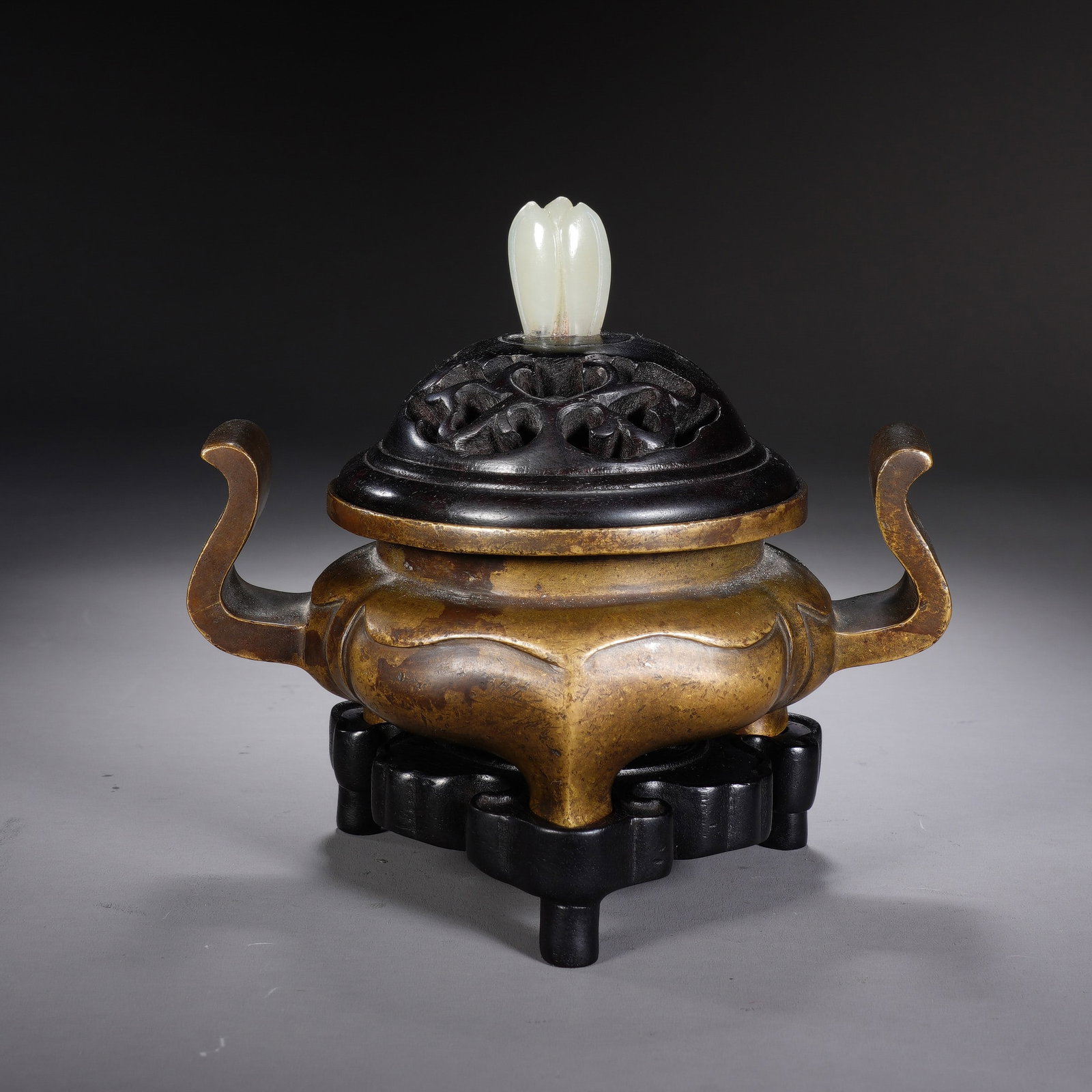 A CHINESE BRONZE CENSER WITH WHITE JADE FINIAL: A CHINESE BRONZE CENSER WITH WHITE JADE FINIAL This begonia-form bronze incense burner measures 12.5cm ? 9cm ? 5.5cm with an overall height of 11.5cm and weighs 553 grams. It features two elegant upwa