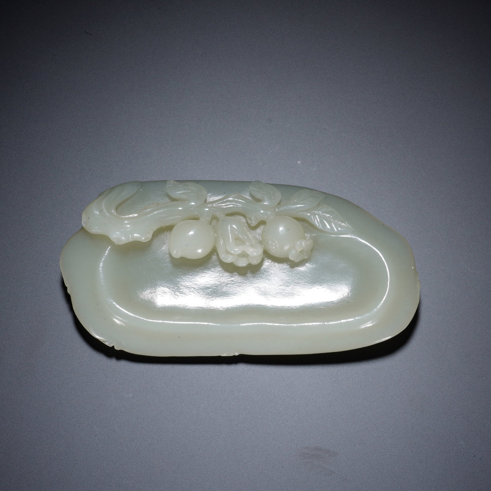 A CHINESE WHITE NEPHRITE INK DISH: A CHINESE WHITE NEPHRITE INK DISH This irregular lobed jade ink washer measures 10.5 cm long, 5.5 cm wide and 1.5 cm thick, weighing 114 grams. Carved from smooth pale white nephrite with a gentle mil