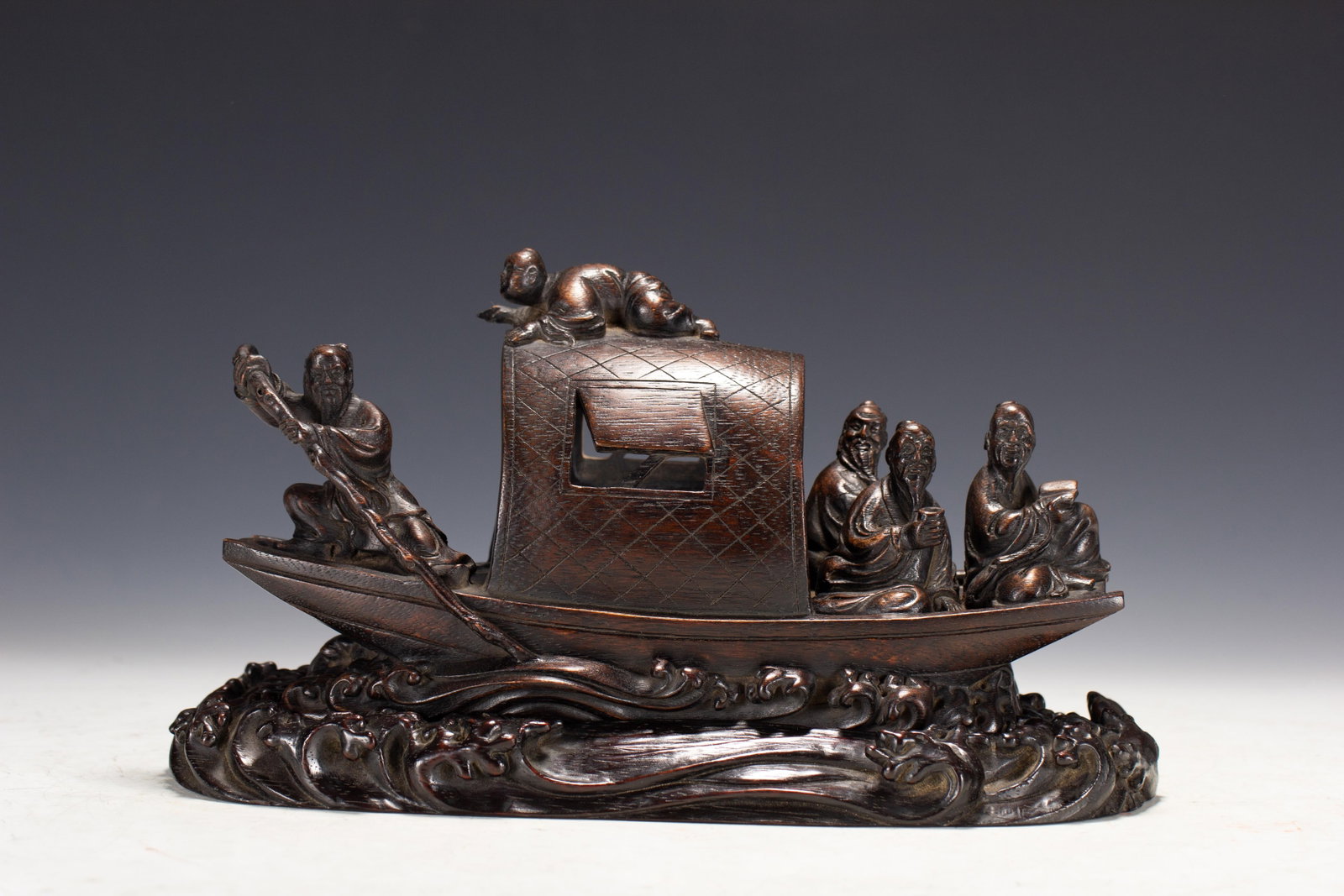 A CHINESE AGARWOOD CARVED BOAT FIGURAL GROUP: A CHINESE AGARWOOD CARVED BOAT FIGURAL GROUP This elaborate decorative carving is crafted entirely from solid agarwood with a rich dark lustrous patina and natural aromatic grain. It depicts a traditi