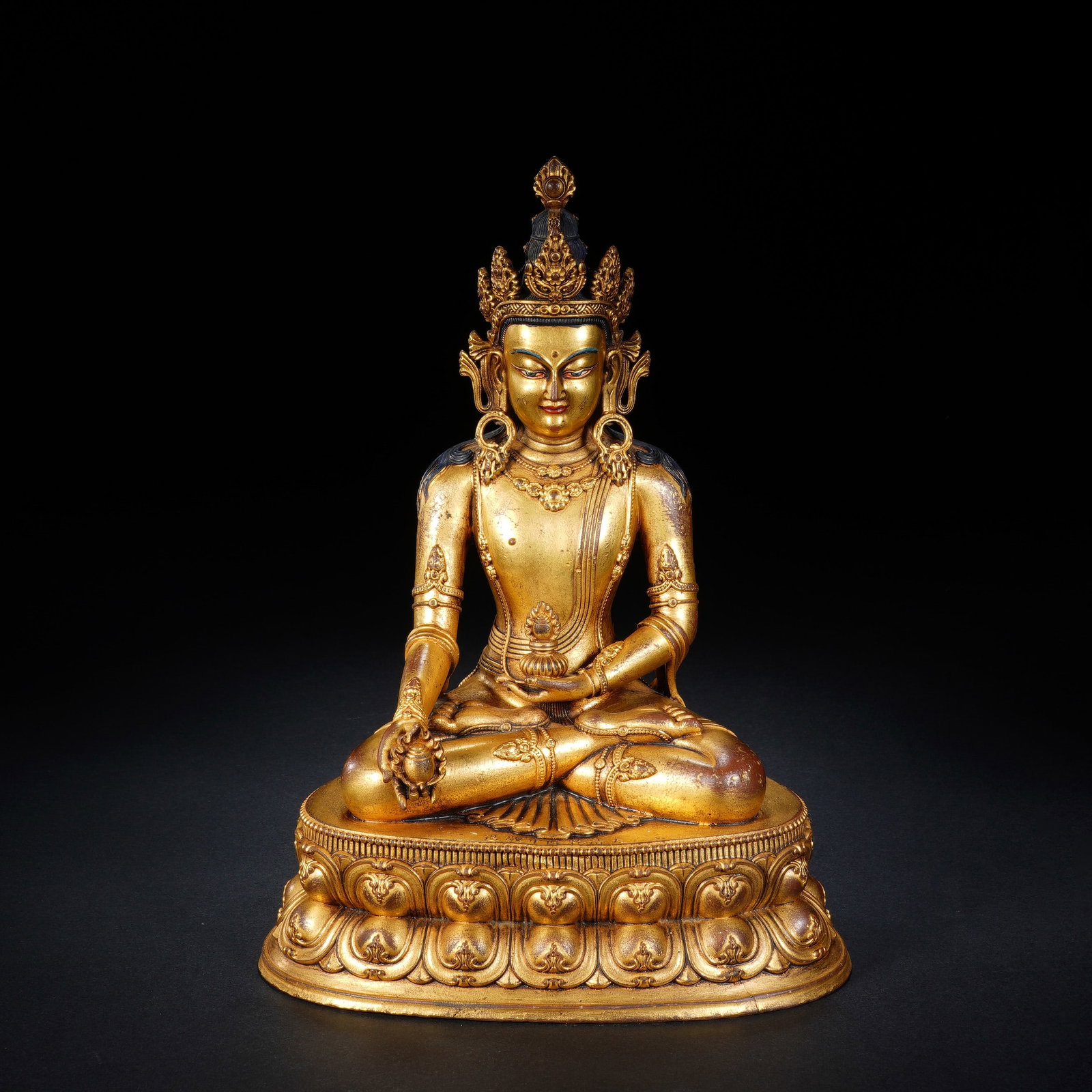 A CHINESE GILT BRONZE SEATED MEDICINE BUDDHA: A CHINESE GILT BRONZE SEATED MEDICINE BUDDHA This gilt bronze Medicine Buddha statue measures 15cm ? 11cm ? 21cm and weighs 1307 grams. The deity sits in full lotus meditation pose atop a double-layer