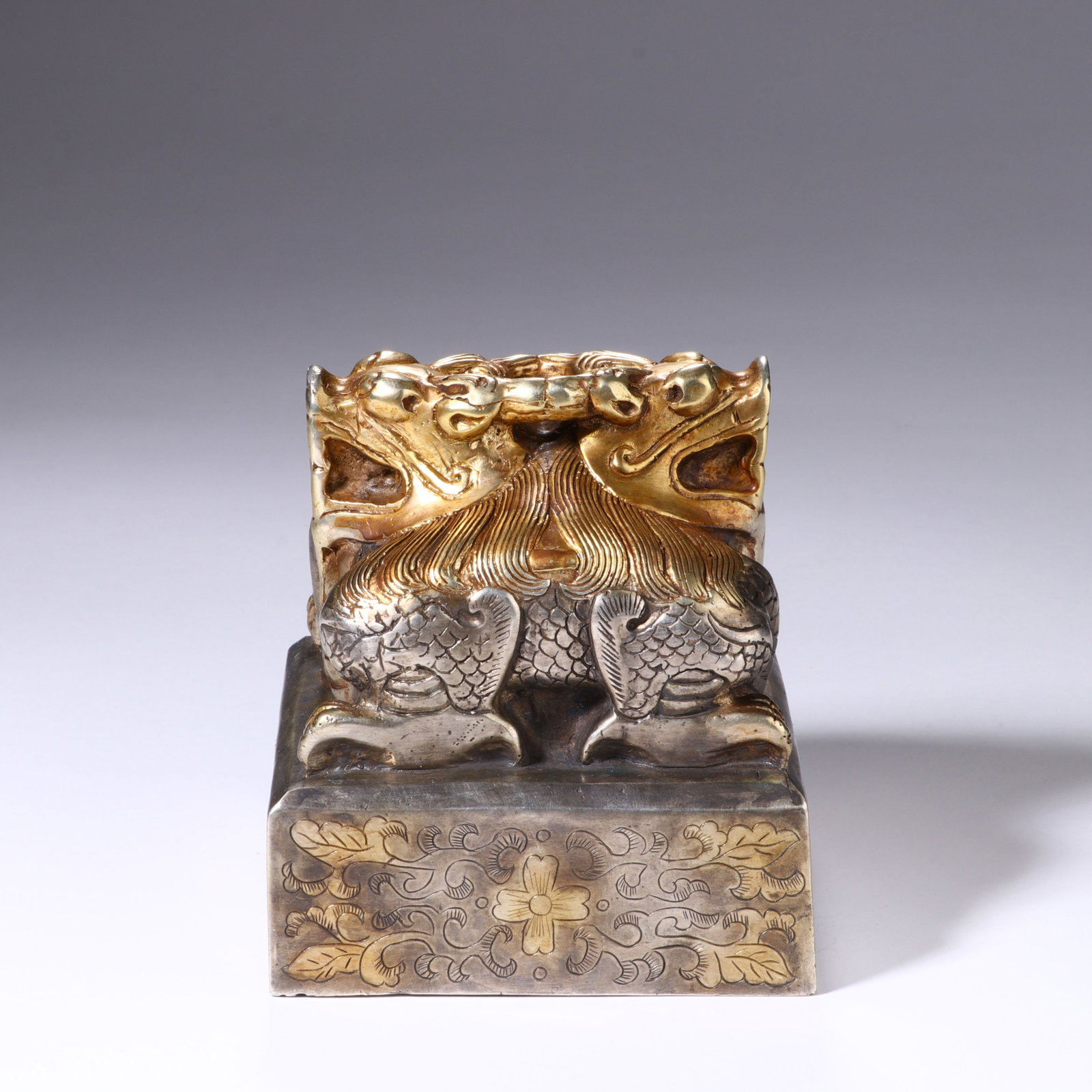 A CHINESE GILT COPPER DOUBLE DRAGON IMPERIAL SEAL: A CHINESE GILT COPPER DOUBLE DRAGON IMPERIAL SEAL This square official seal is cast in copper with selective gilded embellishment. The finial features two intertwined dragons with gilded heads, manes 