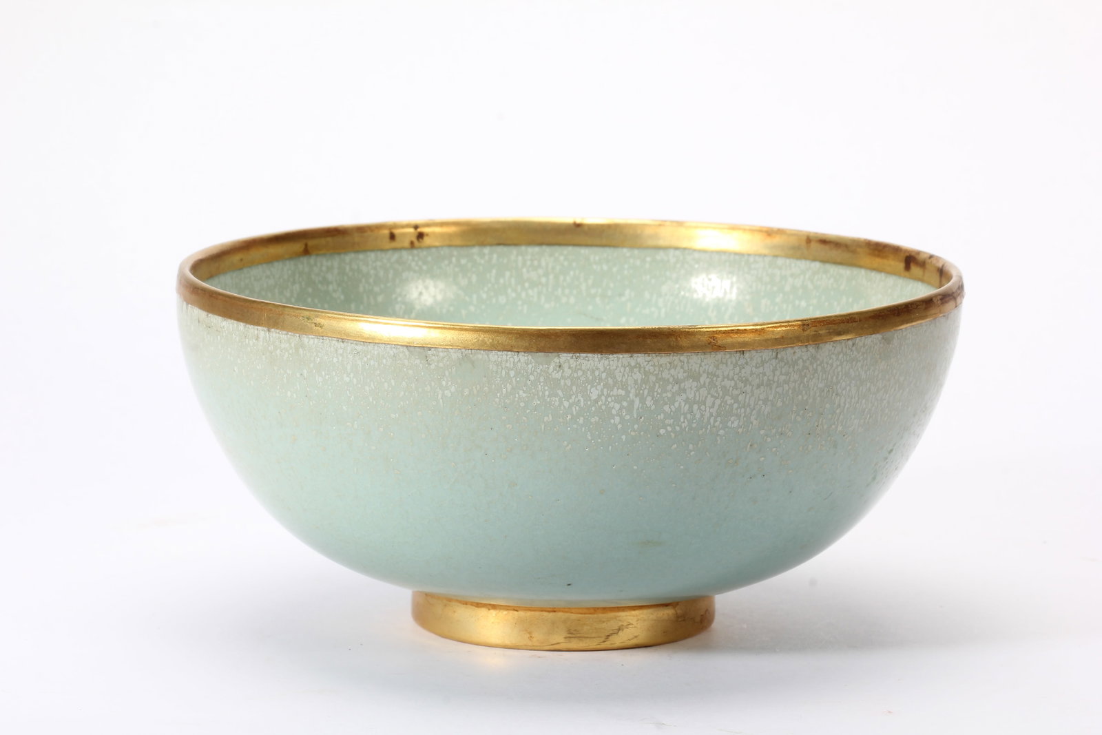 A CHINESE RU-TYPE CELADON BOWL WITH GILT MOUNTED RIM AND FOOT: A CHINESE RU-TYPE CELADON BOWL WITH GILT MOUNTED RIM AND FOOT This elegant rounded porcelain bowl is enveloped in characteristic soft pale sky celadon glaze permeated with subtle fine crackle texture 