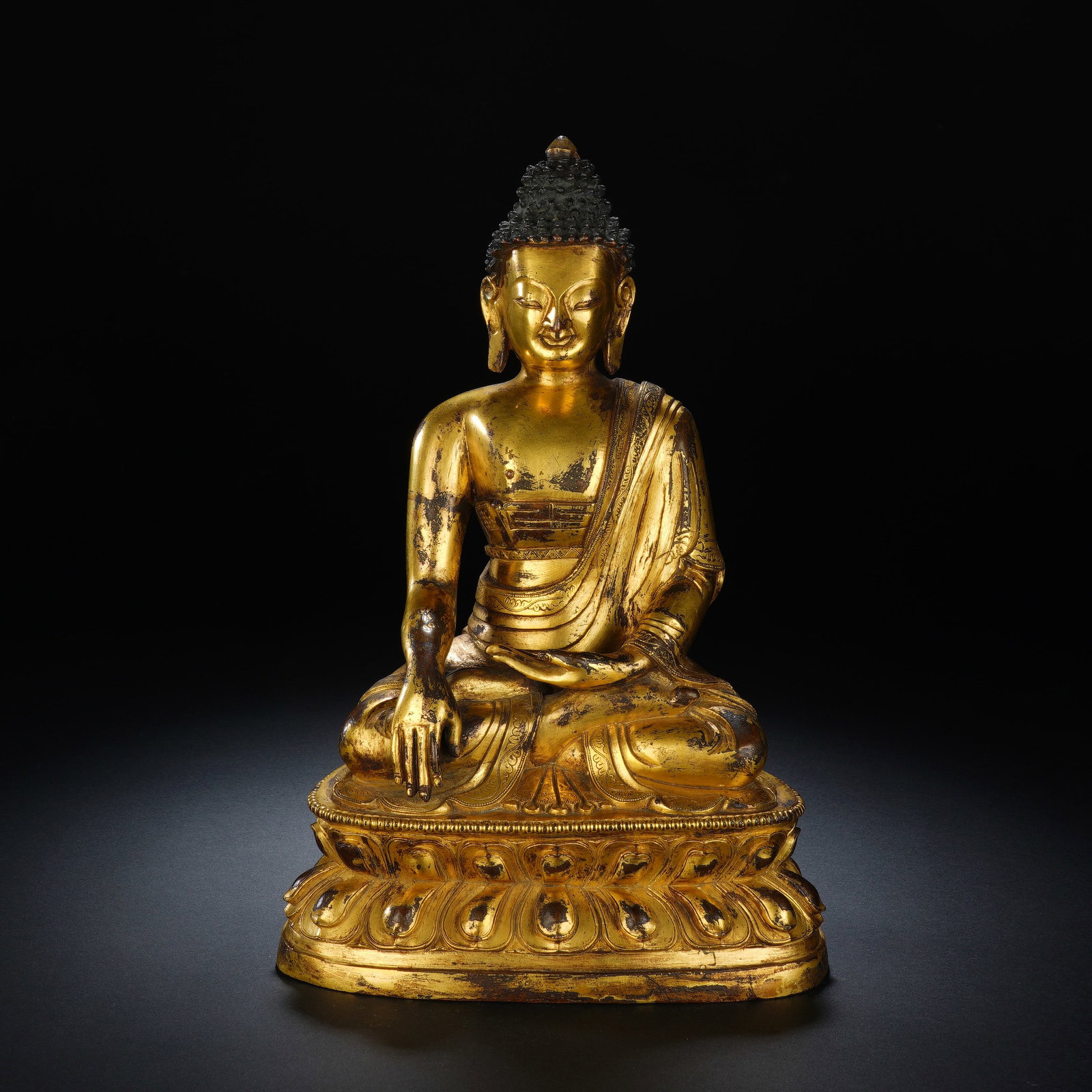 A CHINESE GILT BRONZE MEDICINE BUDDHA STATUE: A CHINESE GILT BRONZE MEDICINE BUDDHA STATUE This fully gilt bronze seated Bhaisajyaguru statue measures 16 cm wide, 11 cm deep and 24 cm tall, weighing 2439 grams. The Buddha rests in full lotus post