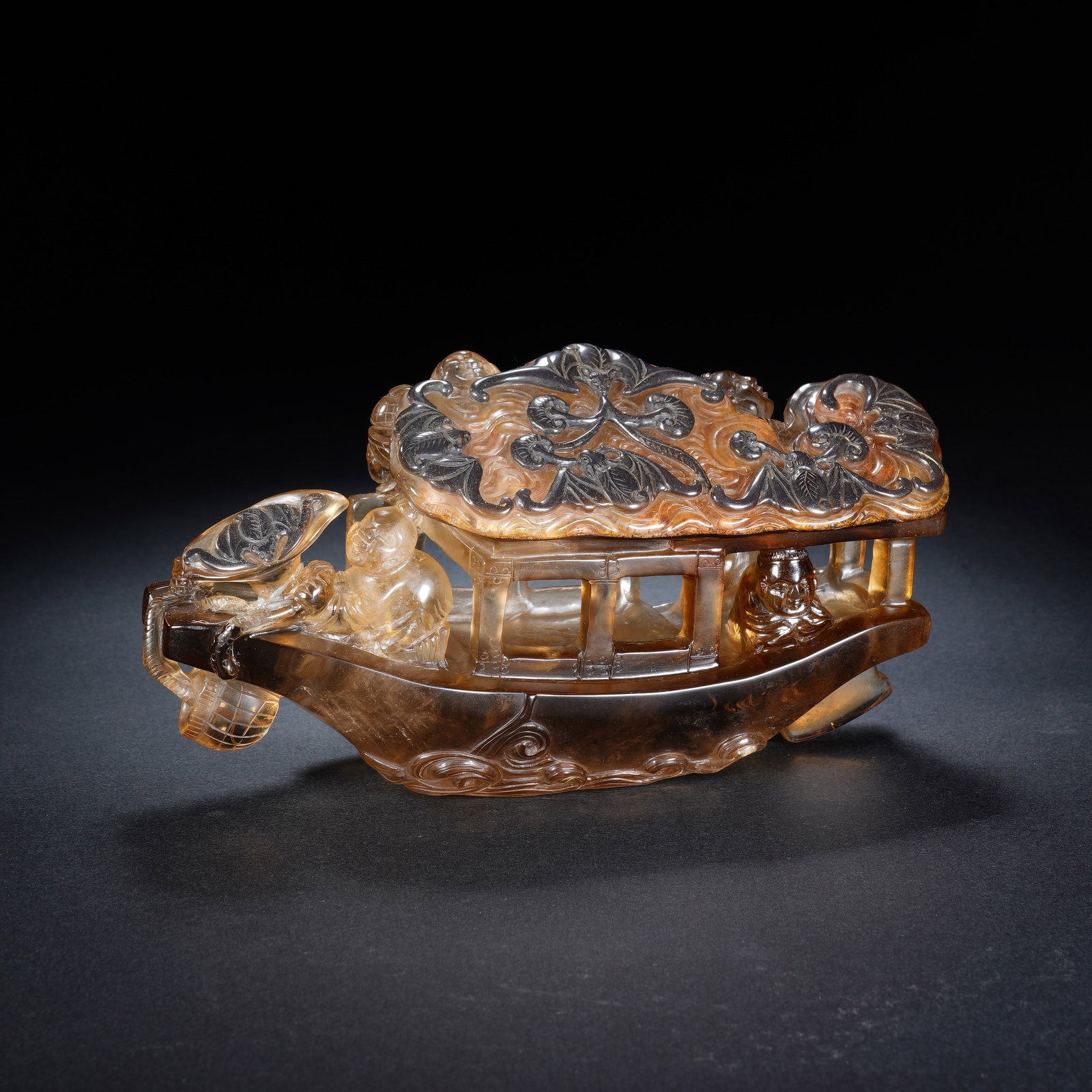 A CHINESE ROCK CRYSTAL BOAT ORNAMENT: A CHINESE ROCK CRYSTAL BOAT ORNAMENT This carved smoky rock crystal boat ornament measures 16 cm long, 6 cm wide and 9 cm tall, weighing 822 grams. Fashioned from translucent amber-toned crystal with 