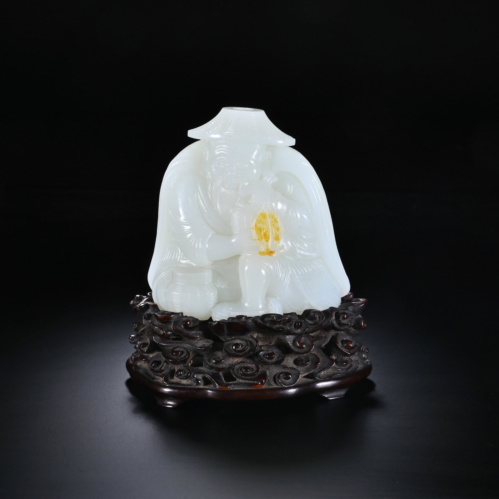 A CHINESE WHITE HETIAN JADE FISHERMAN ORNAMENT: A CHINESE WHITE HETIAN JADE FISHERMAN ORNAMENT This figural carving is rendered from fine milky white Hetian nephrite with a natural warm russet skin retained prominently at the fisherman's chest, ski