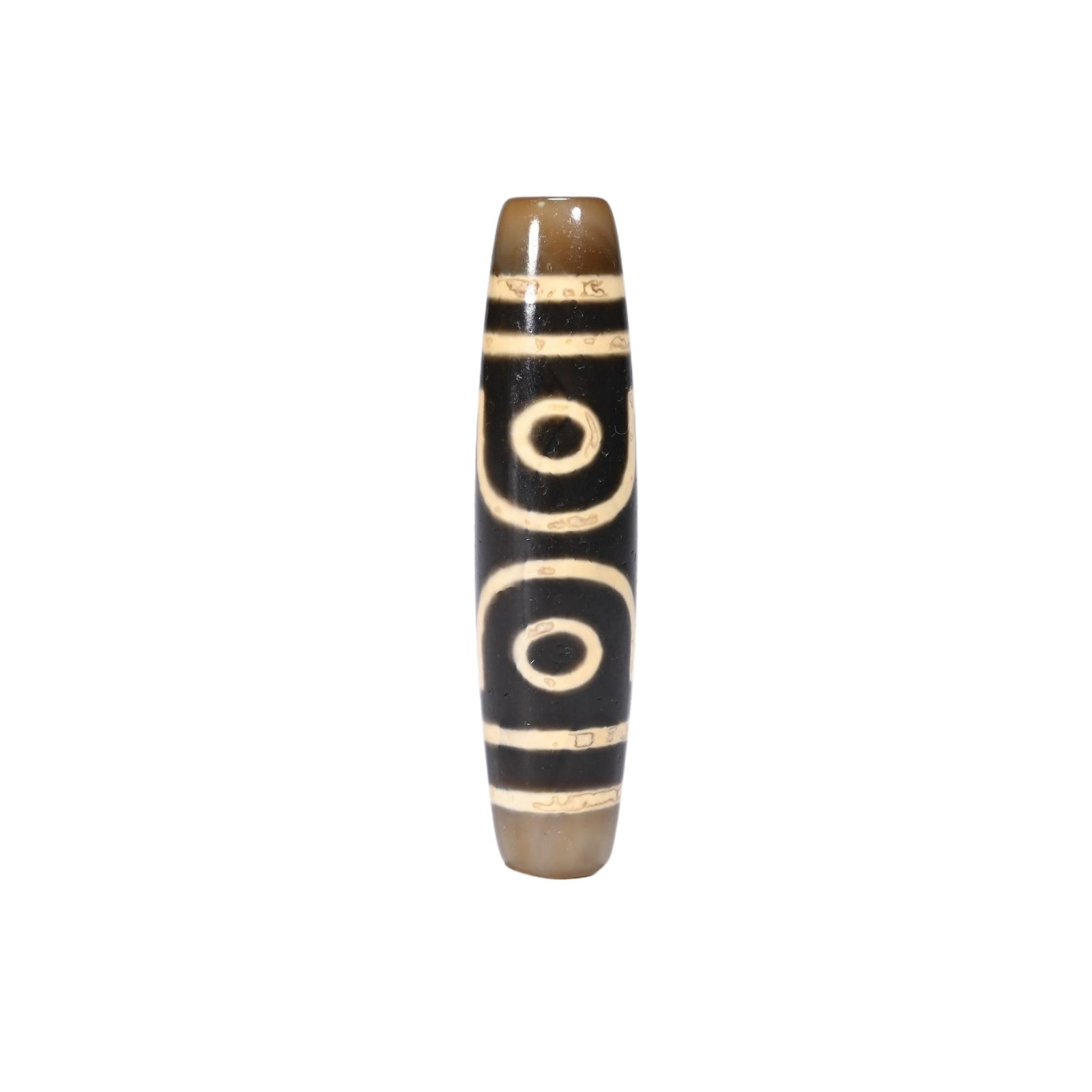 A CHINESE TWO-EYE DZI BEAD: A CHINESE TWO-EYE DZI BEAD This elongated cylindrical dzi bead is crafted from agate with a deep obsidian black base adorned with crisp cream-white etched patterns, featuring two distinct concentric e