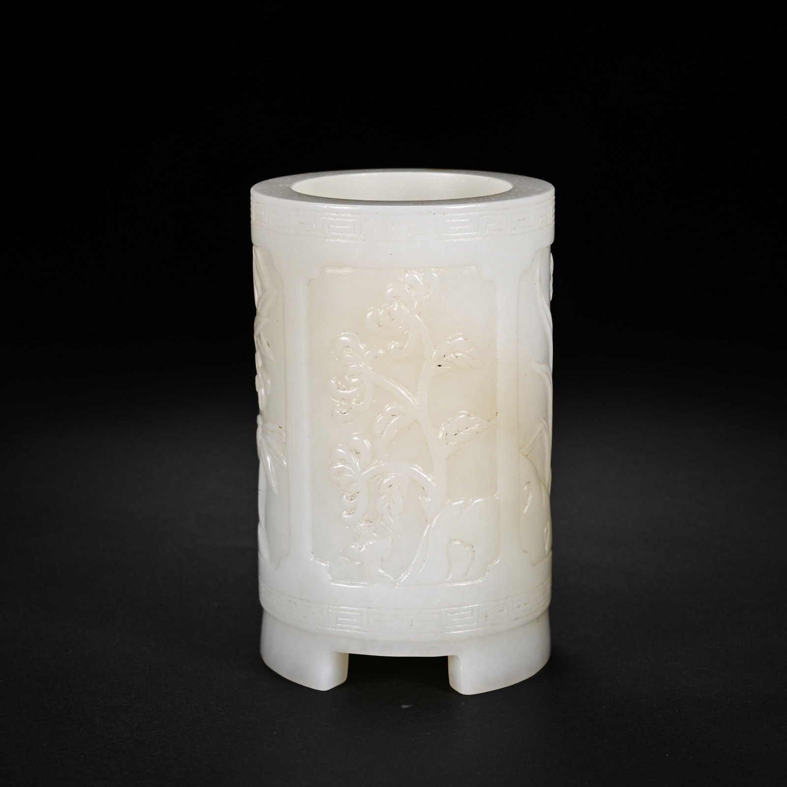 A CHINESE WHITE HETIAN JADE FOUR GENTLEMEN BRUSH POT: A CHINESE WHITE HETIAN JADE FOUR GENTLEMEN BRUSH POT This cylindrical scholar's brush pot is finely hollowed from smooth milky white Hetian nephrite with subtle natural faint russet veining. Its exter