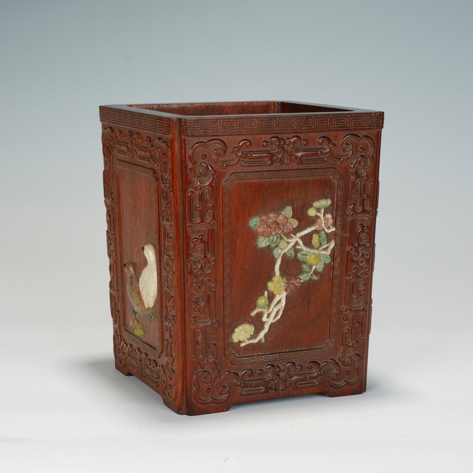 A CHINESE HUANGHUALI SQUARE BRUSH POT: A CHINESE HUANGHUALI SQUARE BRUSH POT This square huanghuali wood brush pot measures 15cm wide, 15cm deep and 18.5cm tall. Each vertical panel is framed by deeply carved scrolling ruyi and geometric k
