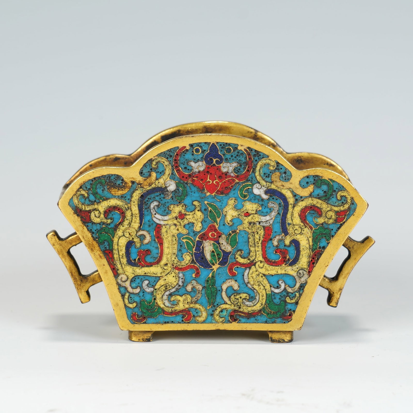 A CHINESE CLOISONNE FAN-SHAPED CENSER: A CHINESE CLOISONNE FAN-SHAPED CENSER This fan-form cloisonne censer measures 10.5 cm wide, 4.5 cm deep and 6.5 cm tall, weighing 284 grams. Mounted on two small gilt metal feet, it features a scallop