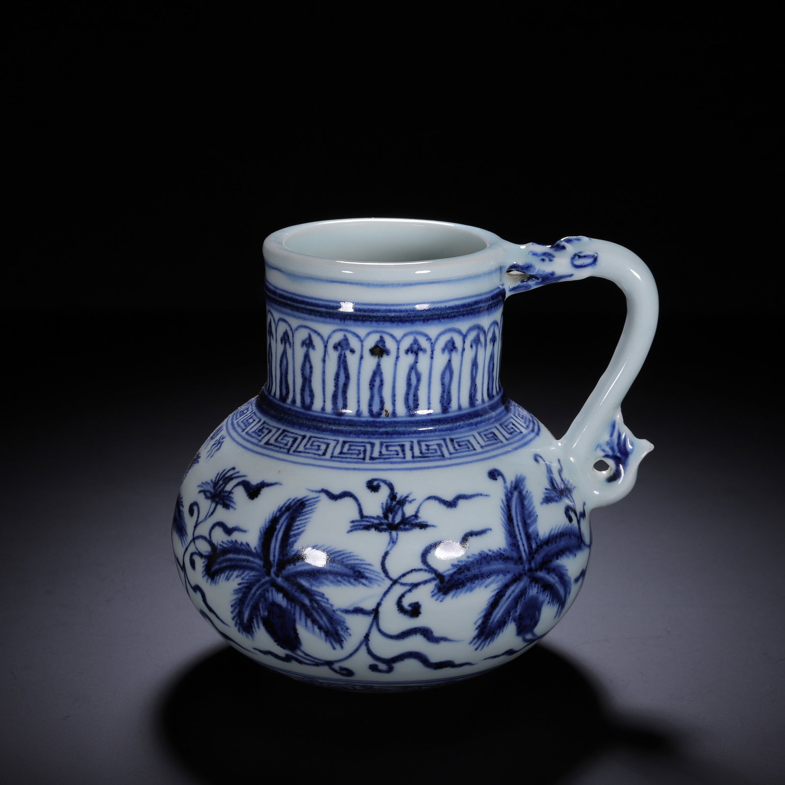A CHINESE BLUE AND WHITE FLORAL HANDLED EWER: A CHINESE BLUE AND WHITE FLORAL HANDLED EWER This globular-bodied porcelain ewer is covered in smooth milky white glaze, richly decorated with saturated underglaze cobalt blue patterns. The bulbous ma