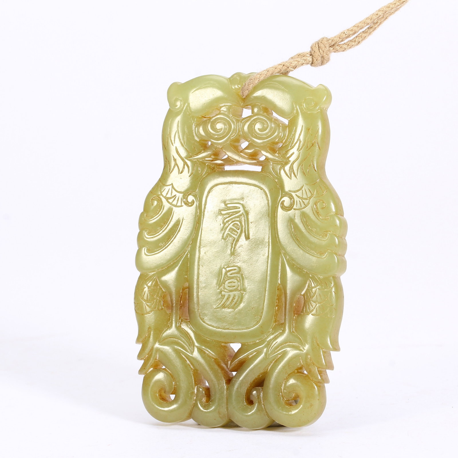 A CHINESE YELLOW JADE TWIN PHOENIX OPENWORK PLAQUE: A CHINESE YELLOW JADE TWIN PHOENIX OPENWORK PLAQUE This pendant plaque is crafted from pale yellow nephrite jade with a smooth glossy finish, executed in intricate openwork carving. Two symmetrical ph