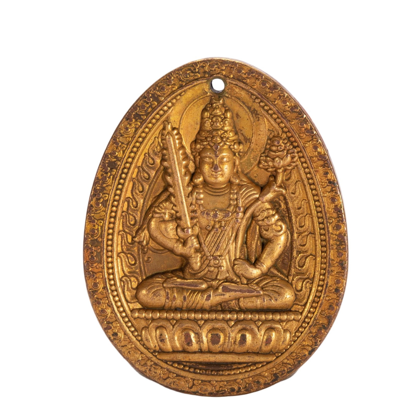 A CHINESE GILT BRONZE MANJUSHRI PENDANT PLAQUE: A CHINESE GILT BRONZE MANJUSHRI PENDANT PLAQUE This oval gilt copper devotional pendant features a small suspension hole at the apex for threading cord. Deep relief carving depicts seated Manjushri, t