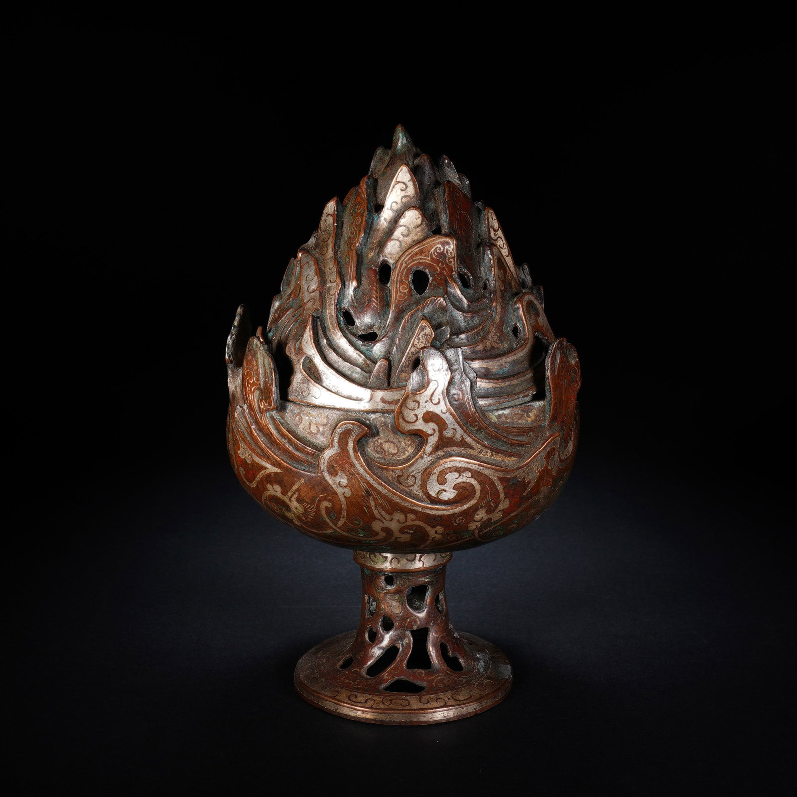 A CHINESE SILVER-INLAID BRONZE BOSHAN CENSER: A CHINESE SILVER-INLAID BRONZE BOSHAN CENSER This bronze mountain-shaped incense burner stands 21 cm tall with a 12 cm wide base, weighing 1382 grams. The entire vessel is meticulously inlaid with fin