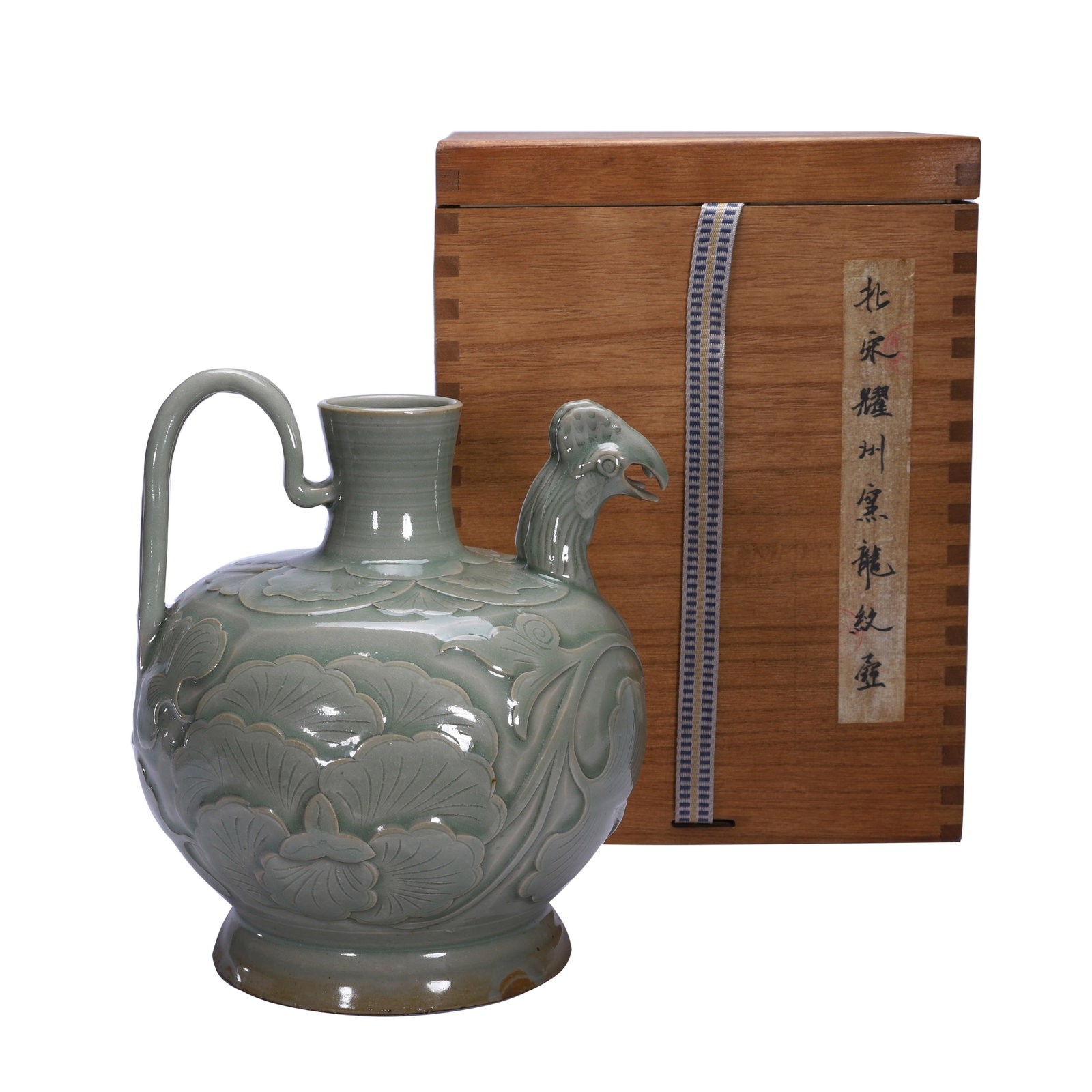 A CHINESE YAOZHOU CELADON PHOENIX EWER: A CHINESE YAOZHOU CELADON PHOENIX EWER This globular wine ewer is entirely covered in uniform soft celadon glaze with subtle natural tonal variations near the foot ring. A finely modelled phoenix head