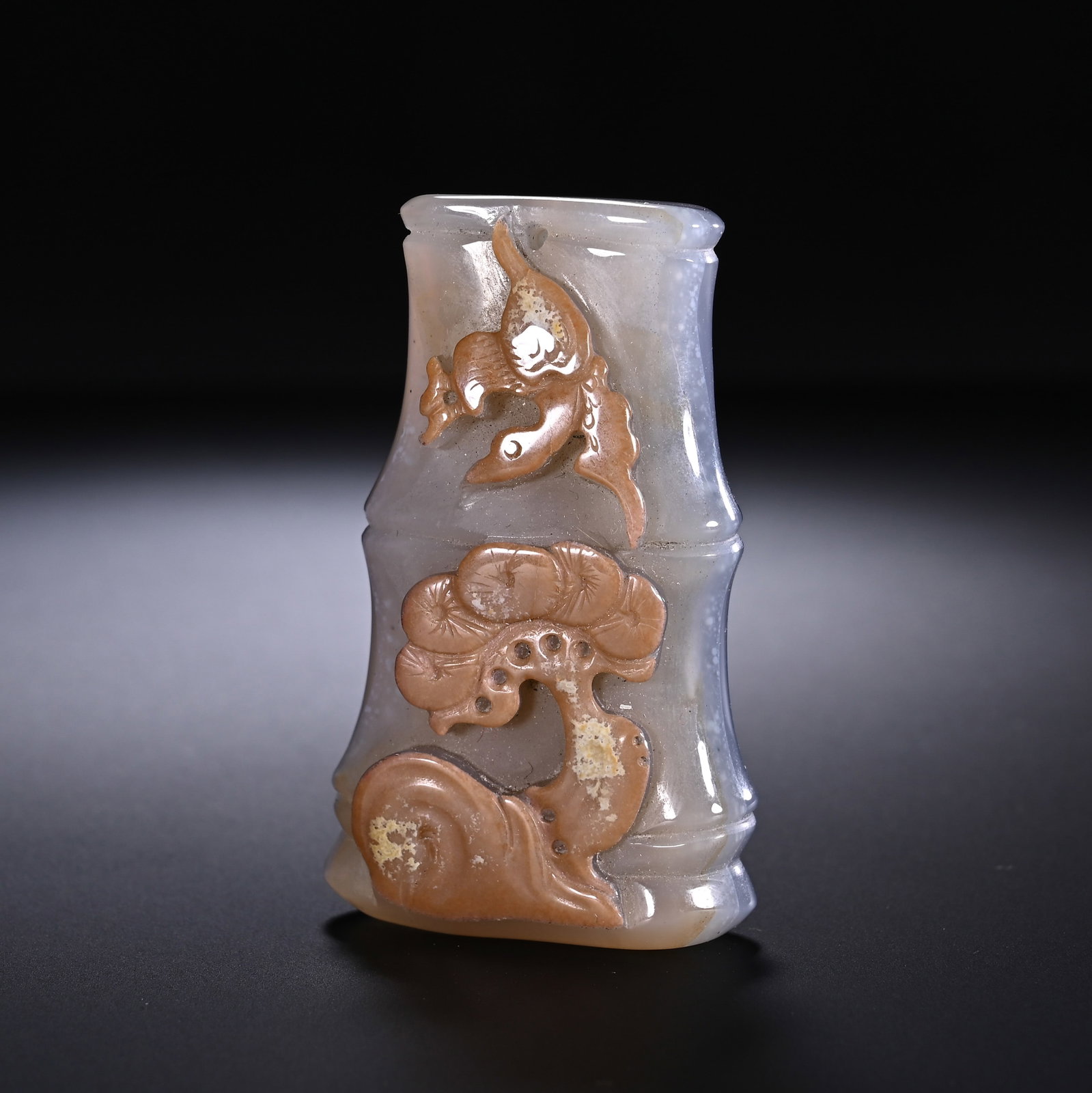A CHINESE CAMEO AGATE BAMBOO-FORM PENDANT TOGGLE: A CHINESE CAMEO AGATE BAMBOO-FORM PENDANT TOGGLE This handheld toggle is carved in the shape of segmented bamboo stalks from translucent pale grey agate, masterfully utilising natural warm russet skin