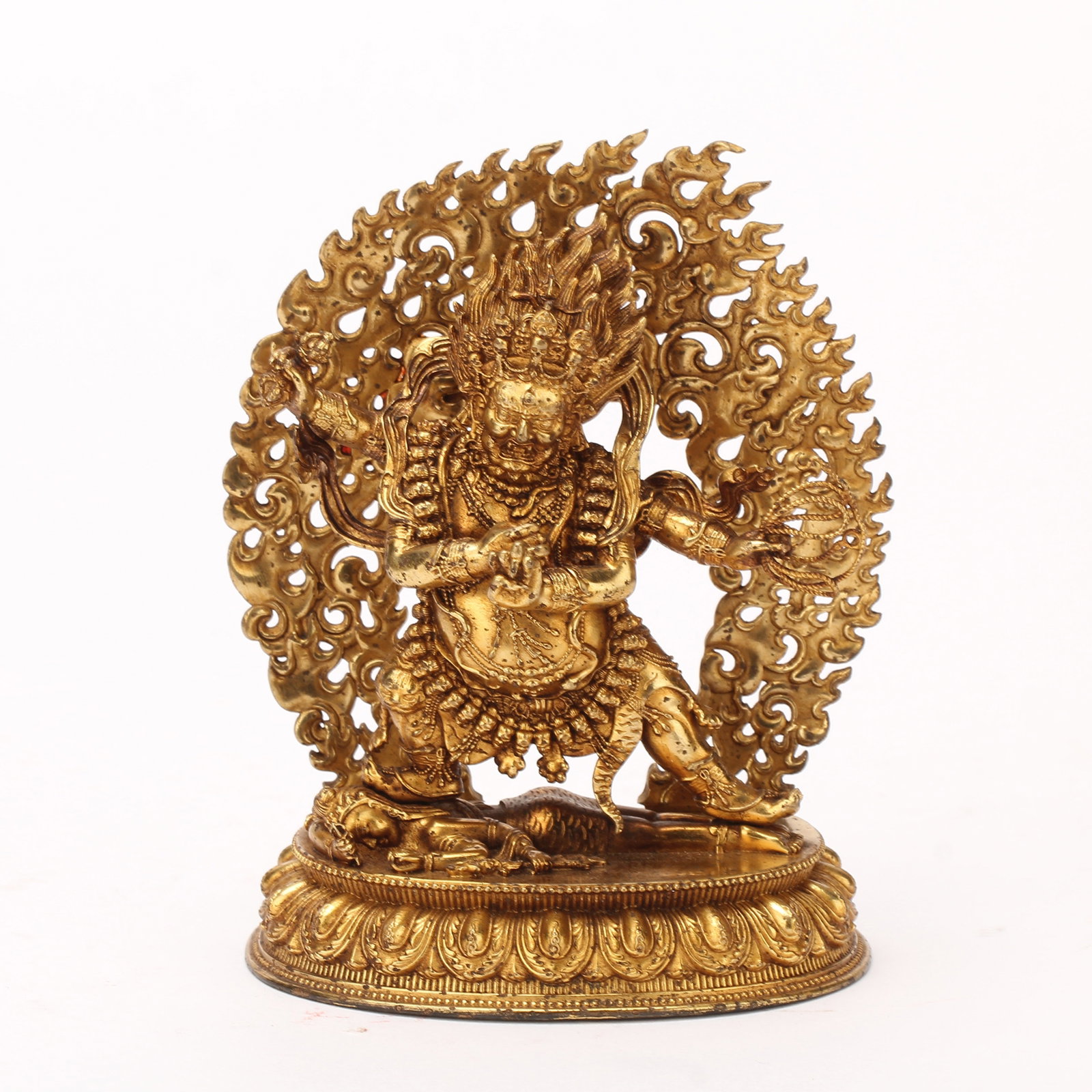 A CHINESE GILT BRONZE MAHAKALA PROTECTOR STATUE: A CHINESE GILT BRONZE MAHAKALA PROTECTOR STATUE This finely cast gilt bronze figure depicts Mahakala in dynamic fierce standing pose atop a double-lotus base with neatly moulded overlapping lotus peta