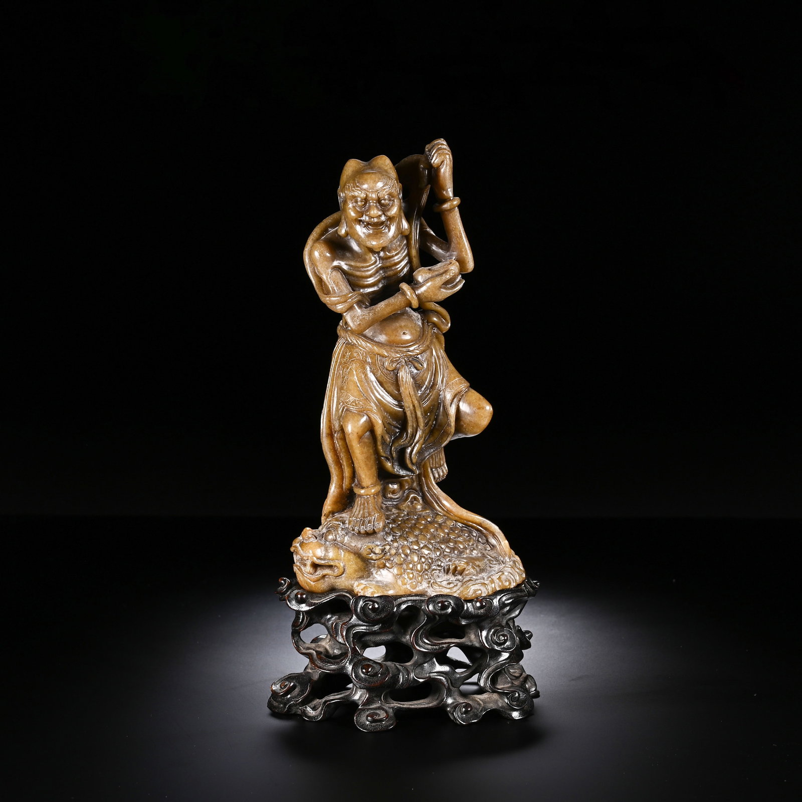 A CHINESE SHOUSHAN STONE LIU HAI AND TOAD ORNAMENT: A CHINESE SHOUSHAN STONE LIU HAI AND TOAD ORNAMENT This figural sculpture is finely carved from solid Shoushan stone with a warm aged amber-brown patina and smooth polished surface. It depicts Liu Hai
