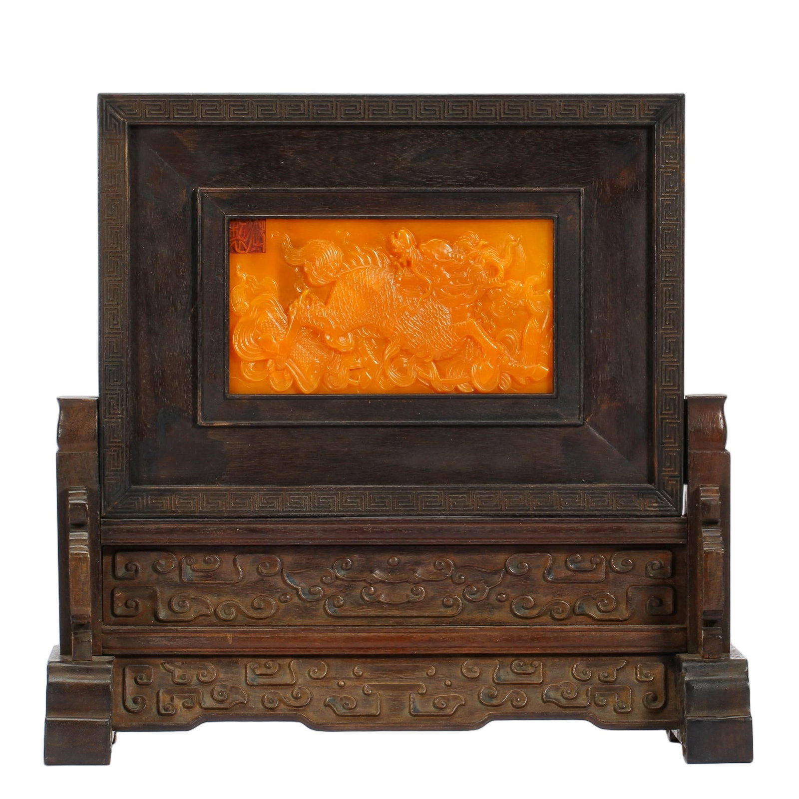 A CHINESE TIANHUANG STONE QILIN TABLE SCREEN: A CHINESE TIANHUANG STONE QILIN TABLE SCREEN This decorative table screen features a bright warm orange Tianhuang stone plaque inset within a polished hardwood frame. The stone panel is finely carved 