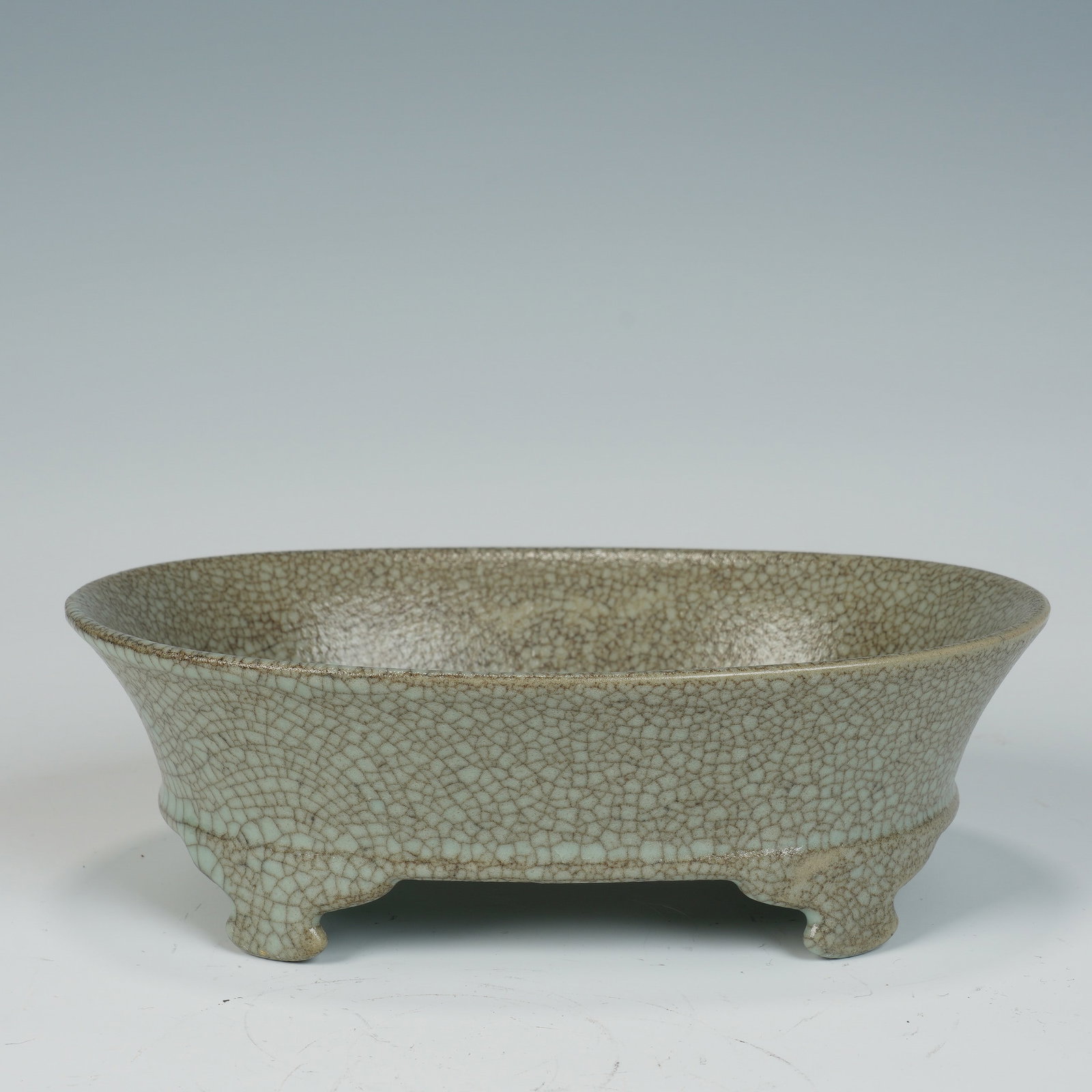 A CHINESE GE CRACKLE GLAZE OVAL PLANTER: A CHINESE GE CRACKLE GLAZE OVAL PLANTER This oval ge ware planter measures 20cm ? 15cm ? 6.5cm, crafted with a wide flared rim and gently tapering curved walls supported by four short rounded feet. Th