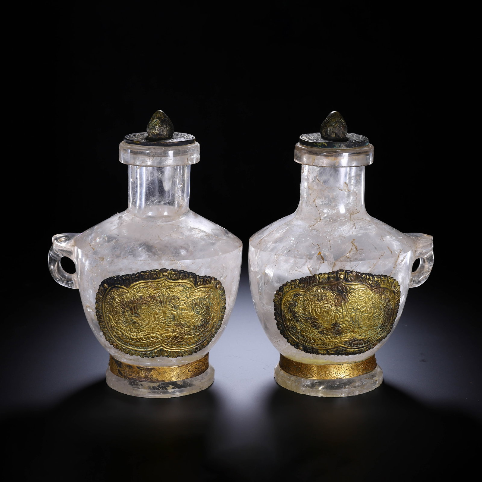 A PAIR OF CHINESE ROCK CRYSTAL GILT MOUNTED VASES: A PAIR OF CHINESE ROCK CRYSTAL GILT MOUNTED VASES A matching pair of handled vessels carved from natural clear rock crystal with subtle natural inclusions throughout the translucent stone. Each vase i
