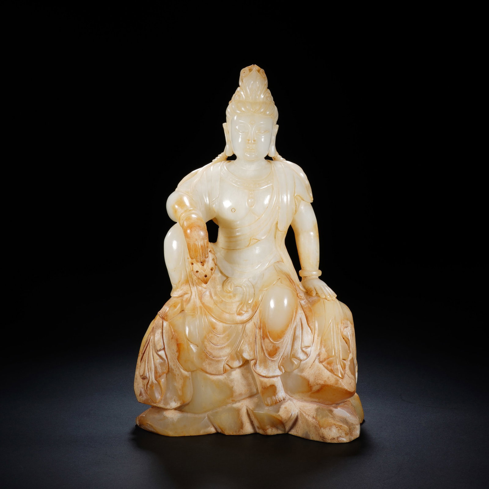 A CHINESE JADE SEATED FREE GUANYIN STATUE: A CHINESE JADE SEATED FREE GUANYIN STATUE This jade Guanyin figure measures 15cm ? 7cm ? 25cm and weighs 2909 grams, carved in the relaxed "Free Guanyin" pose atop rugged rockwork base. The deity rest