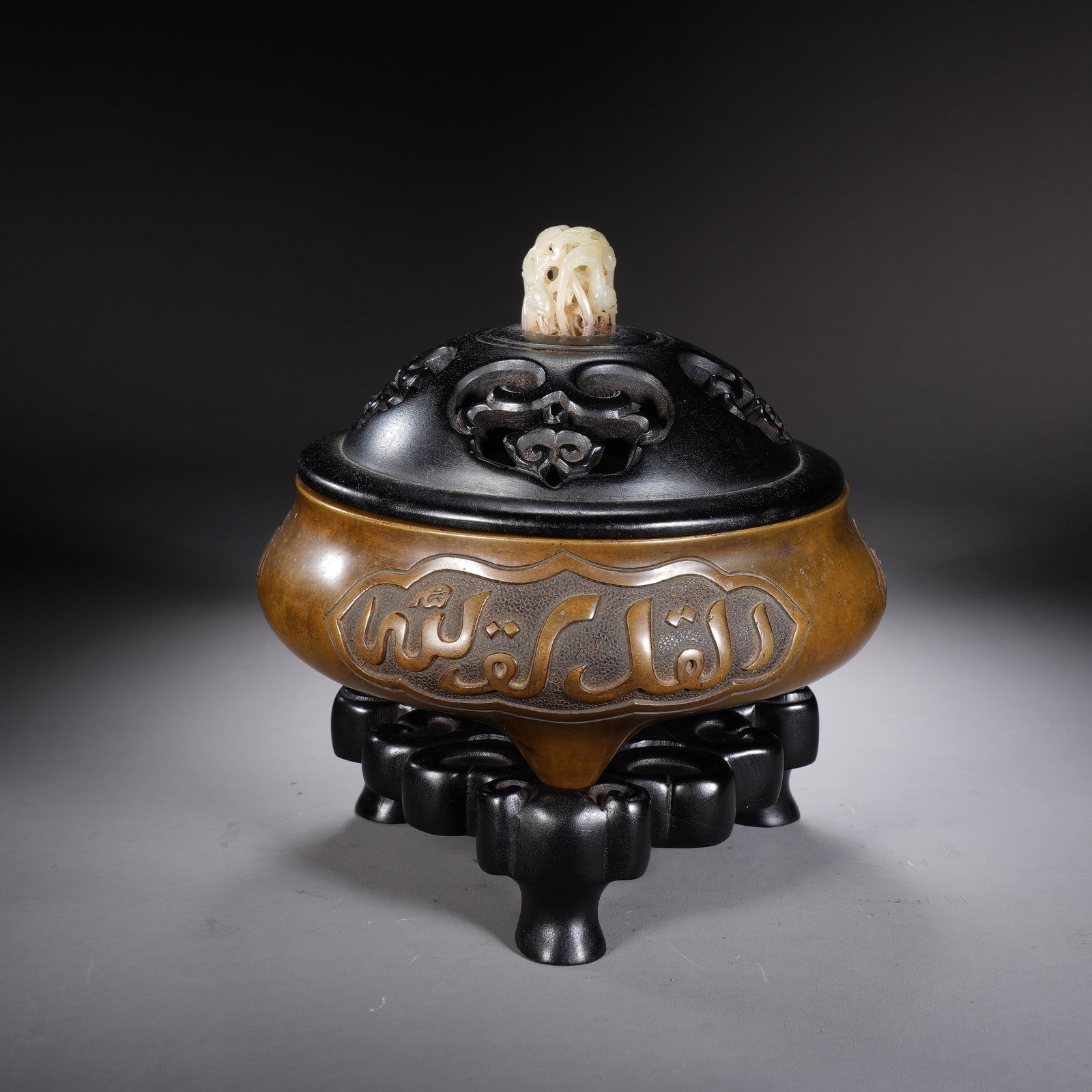 A CHINESE BRONZE TRIPOD CENSER WITH ARABIC SCRIPT: A CHINESE BRONZE TRIPOD CENSER WITH ARABIC SCRIPT This round bronze incense burner has a body width of 15cm, height of 6cm, total overall height 15cm and weighs 1442 grams. The bulbous body is raised 