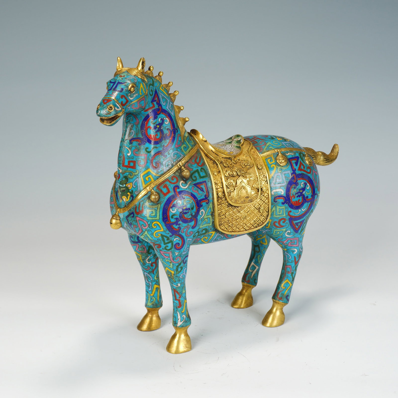 A CHINESE CLOISONNE HORSE FIGURE: A CHINESE CLOISONNE HORSE FIGURE This single cloisonne equine sculpture measures 34 cm long, 11 cm wide and 32 cm tall, weighing 4554 grams. The standing steed is crafted with a turquoise enamel groun
