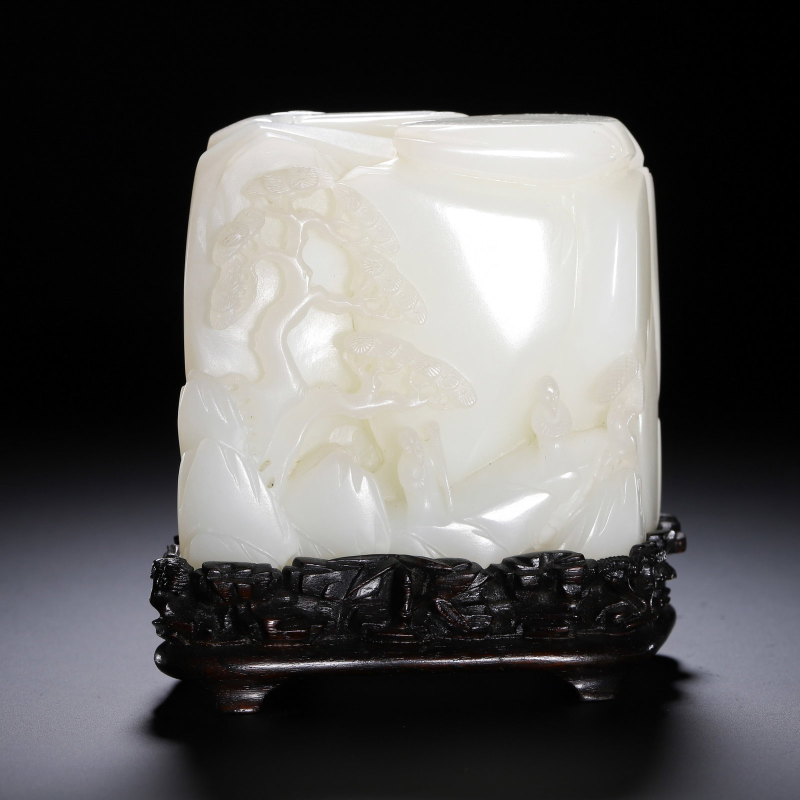 A CHINESE WHITE JADE LANDSCAPE BOULDER ORNAMENT: A CHINESE WHITE JADE LANDSCAPE BOULDER ORNAMENT This square mountain boulder is carved from top-grade milky white Hetian nephrite with a sleek lustrous polish. One face features layered relief scenery
