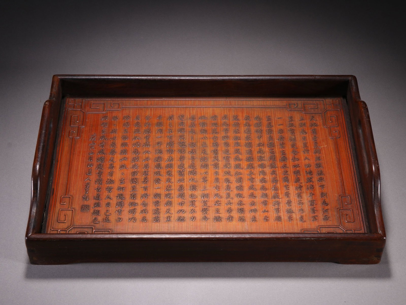 A CHINESE HARDWOOD TRAY WITH CARVED BAMBOO POEM INLAY: A CHINESE HARDWOOD TRAY WITH CARVED BAMBOO POEM INLAY Measuring 32.4cm long, 12cm wide and weighing 636.9 grams, this rectangular scholar's tray is framed by polished dark red hardwood with curved sid