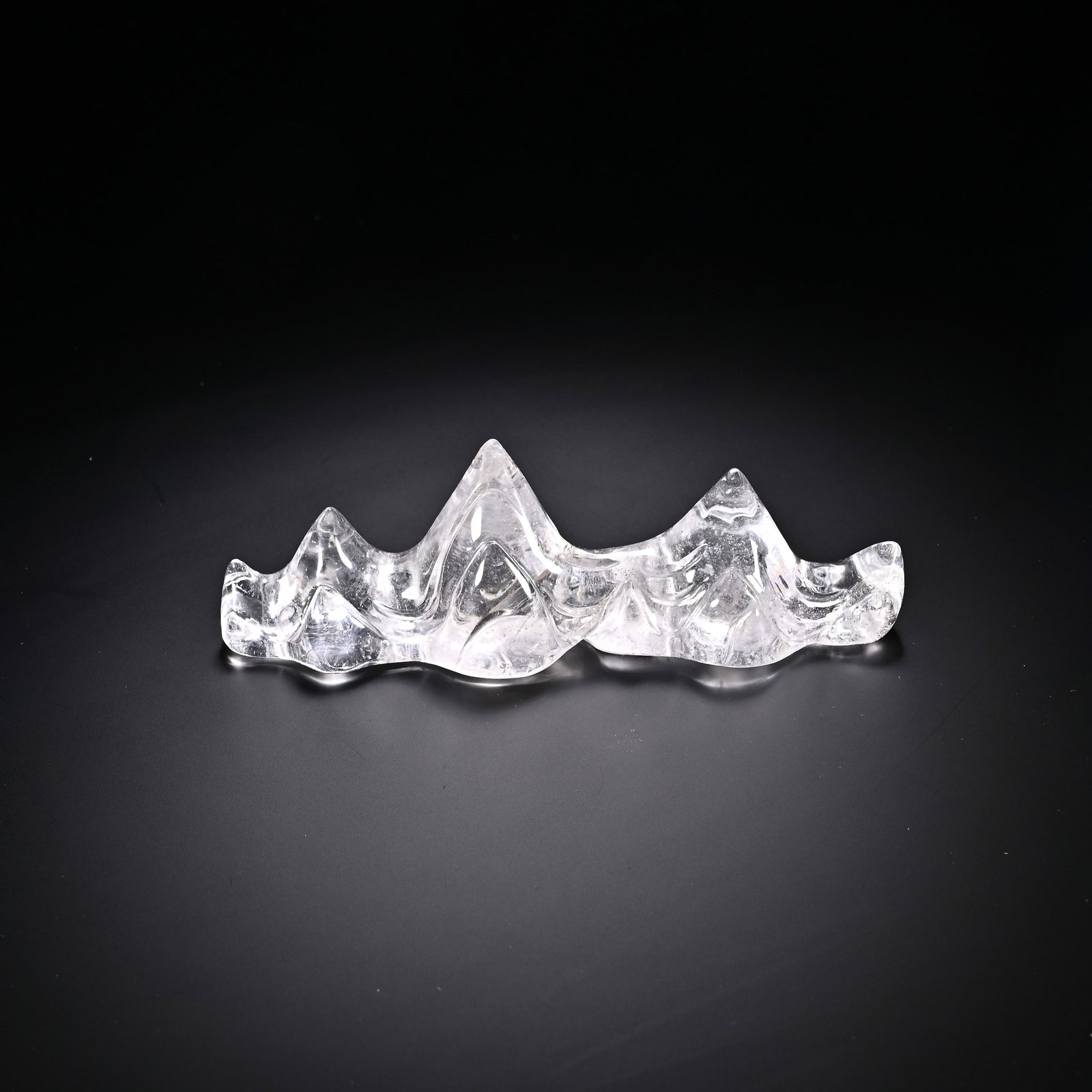 A CHINESE ROCK CRYSTAL MOUNTAIN-FORM BRUSH REST: A CHINESE ROCK CRYSTAL MOUNTAIN-FORM BRUSH REST This scholar's stationery ornament is carved from natural clear rock crystal, shaped as a continuous range of undulating mountain peaks with three promi