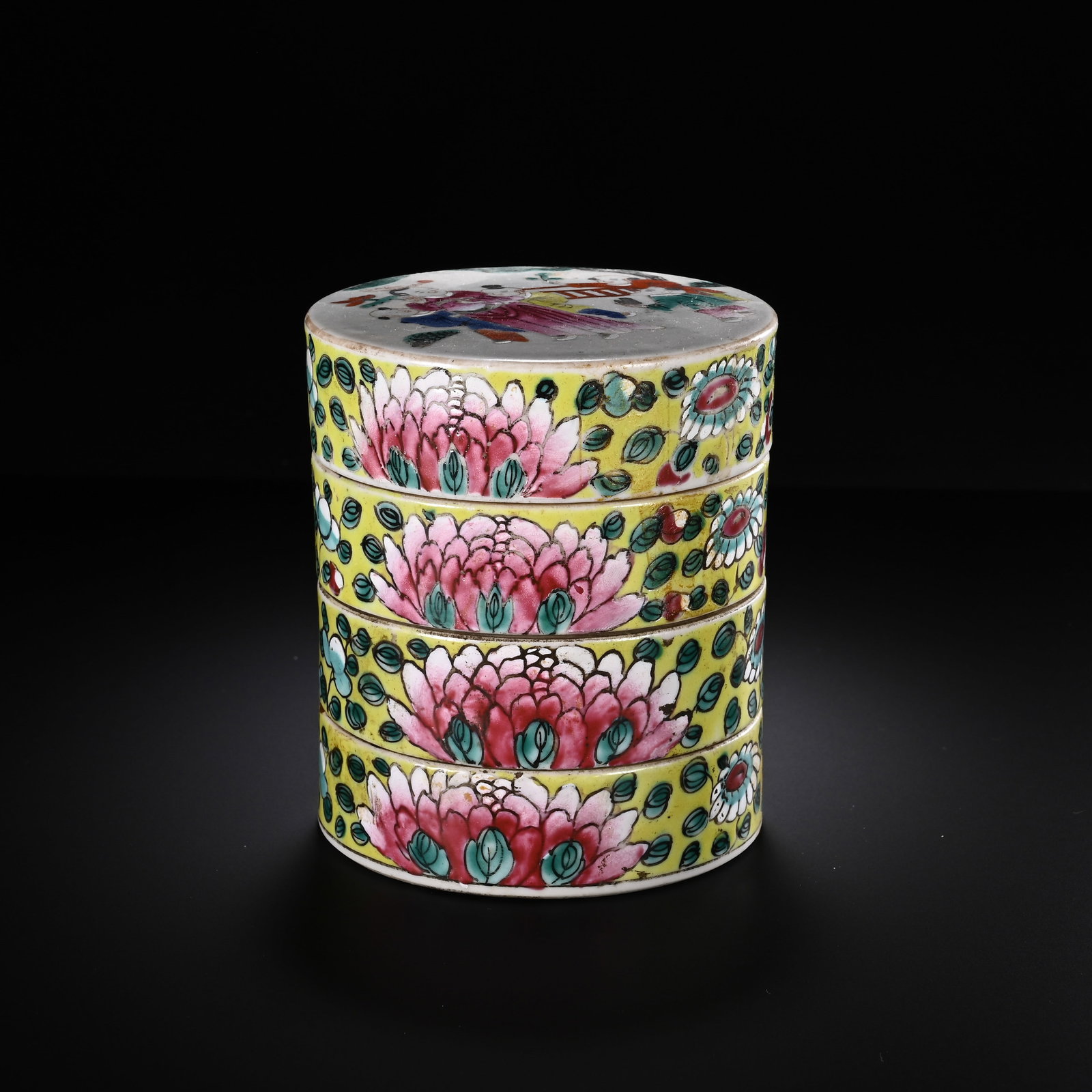 A CHINESE FAMILLE ROSE FOUR-TIERED CIRCULAR STACKING BOX: A CHINESE FAMILLE ROSE FOUR-TIERED CIRCULAR STACKING BOX This multi-tiered cylindrical cosmetic box consists of four stacked porcelain trays capped with a decorated cover. The exterior is glazed with 