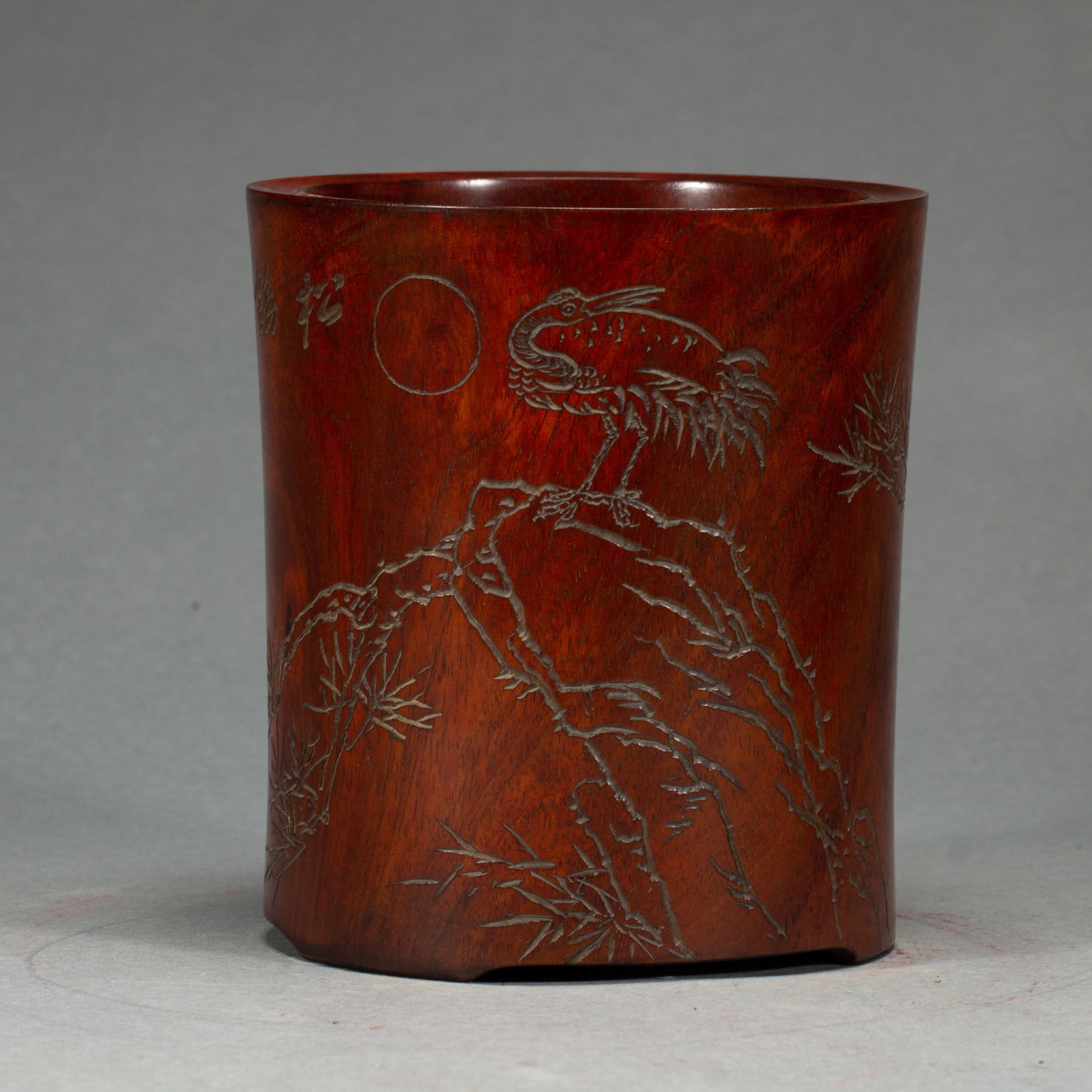 A CHINESE HUANGHUALI WOOD BRUSH POT: A CHINESE HUANGHUALI WOOD BRUSH POT A solid cylindrical brush pot carved from natural huanghuali wood with warm rich reddish-brown patina and distinct natural grain. Its exterior is finely incised wit