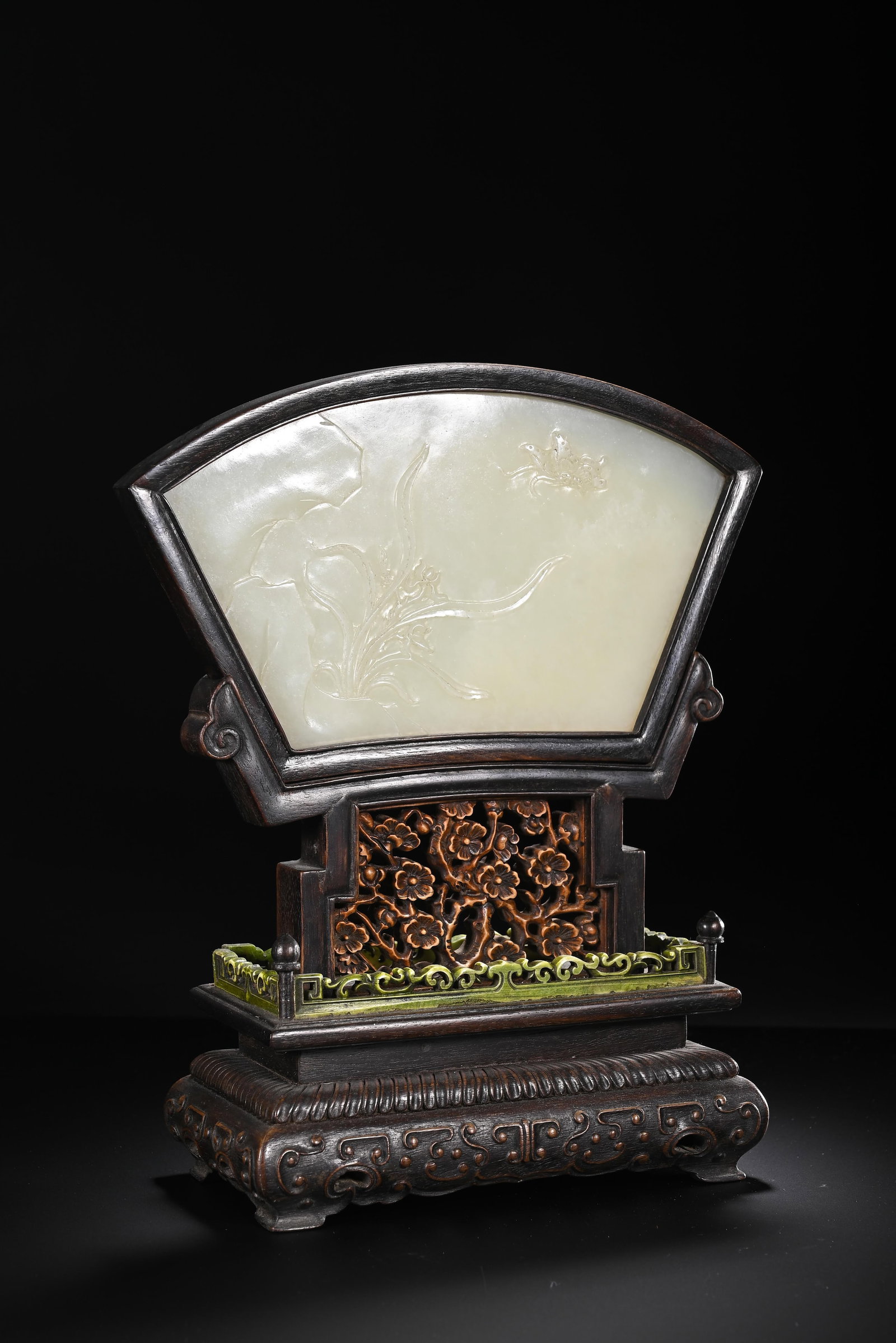 A CHINESE WHITE JADE ORCHID FAN-SHAPED TABLE SCREEN: A CHINESE WHITE JADE ORCHID FAN-SHAPED TABLE SCREEN This decorative table screen features a fan-shaped plaque carved from creamy white nephrite jade, subtly incised with elegant orchid blossoms, slend