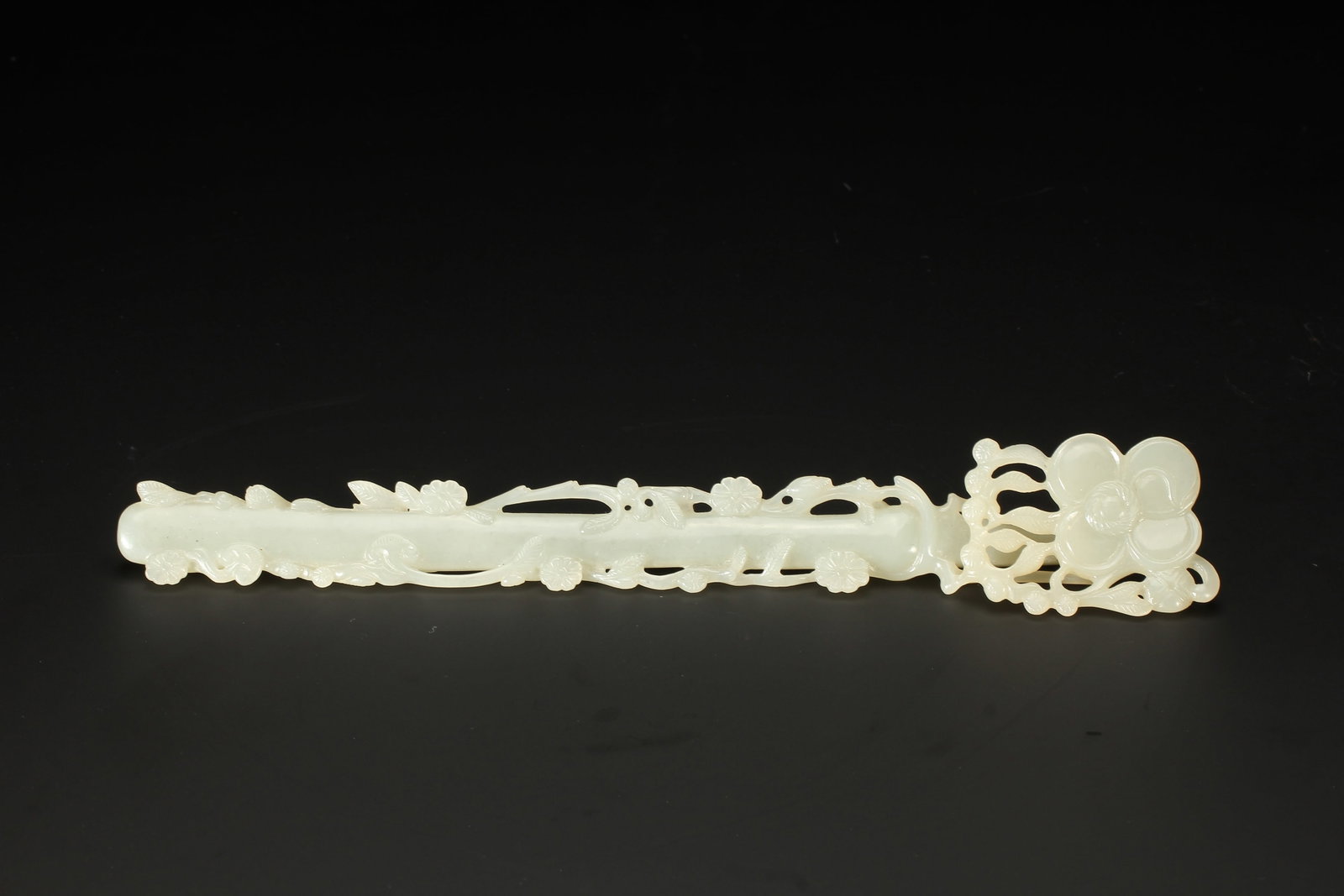 A CHINESE WHITE HETIAN JADE FLORAL RUYI SCEPTER: A CHINESE WHITE HETIAN JADE FLORAL RUYI SCEPTER This slender ruyi is carved from smooth creamy white Hetian nephrite jade with a subtle gentle luster. The head is fully openworked into a large blossom