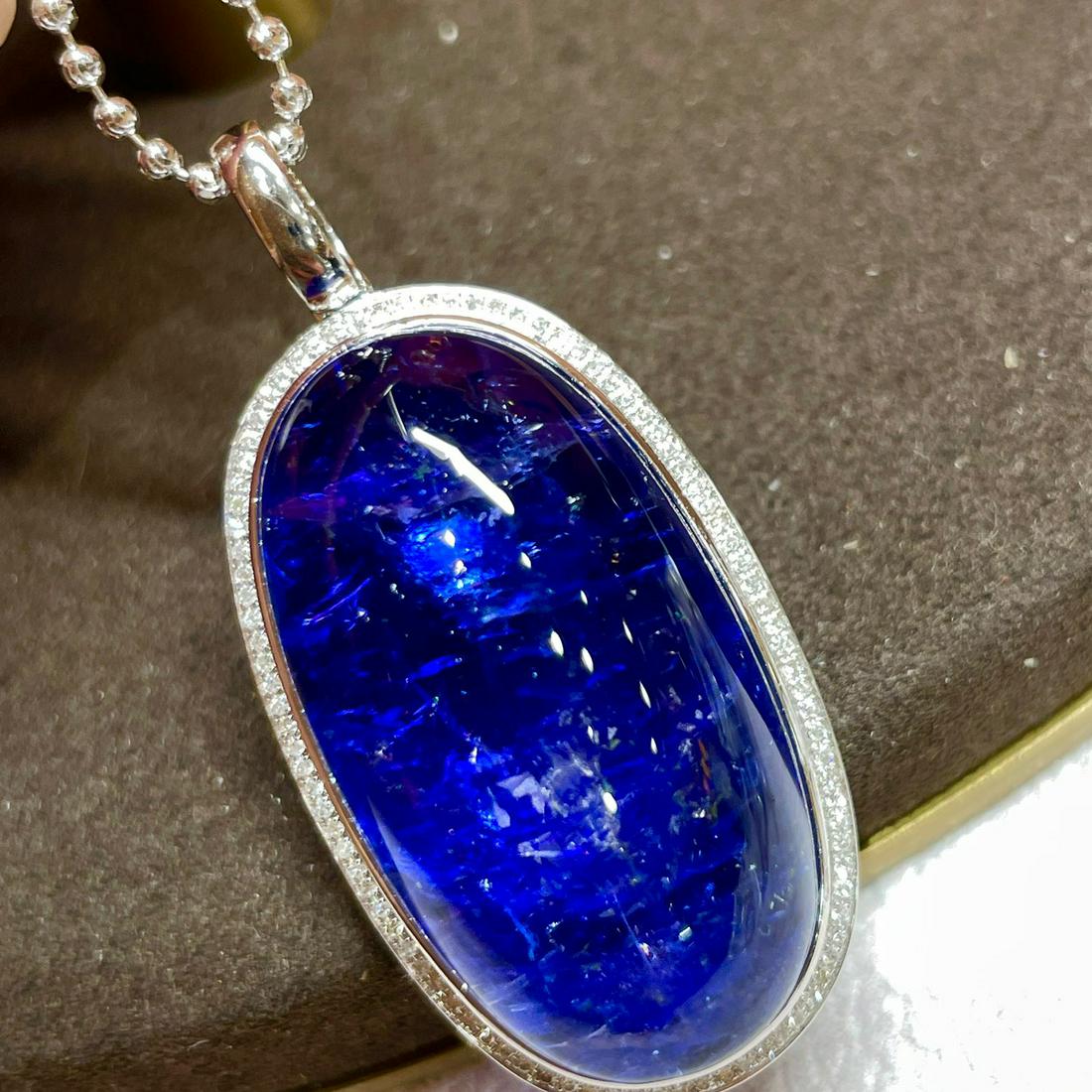 14K WHITE GOLD 48.38 CTW VIVID BLUE NATURAL TANZANITE & DIAMOND PENDANT: Ref:23319182 Gold Content:14K White Gold Main Gemstone:Natural Tanzanite Number of stones:1 Shape:Oval Carat Weight:48.38ct Color:Vivid Blue Cut Grade:G Adjacent Gemstone 2 : Diamond Shape:Round